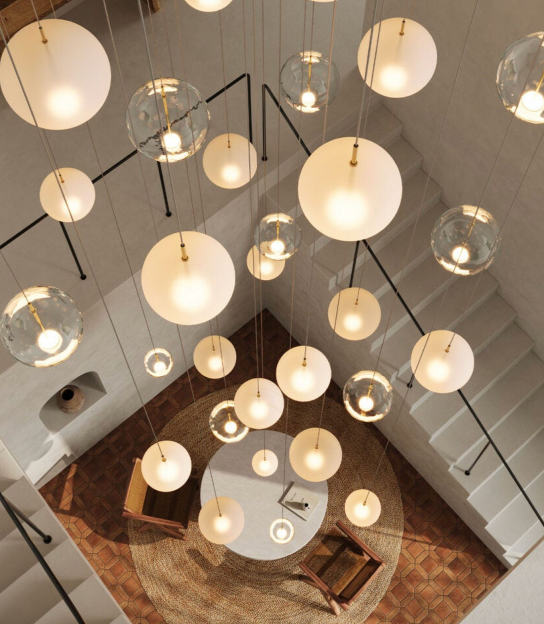 Cluster of Orb Air pendant lights hanging in a staircase void with high ceilings
