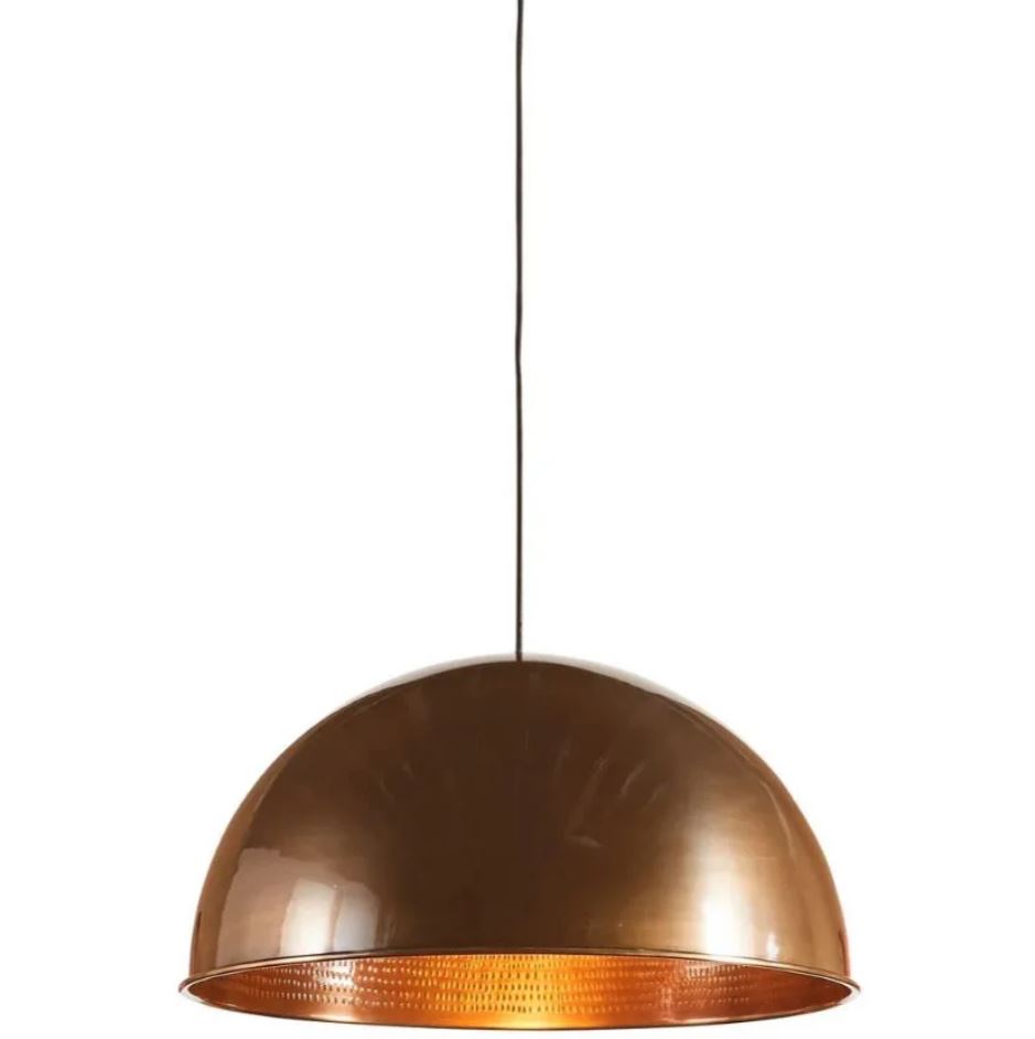 A modern industrial pendant light with a brass metal dome, featuring a copper exterior and a polished brass interior, suspended above a living room setting.