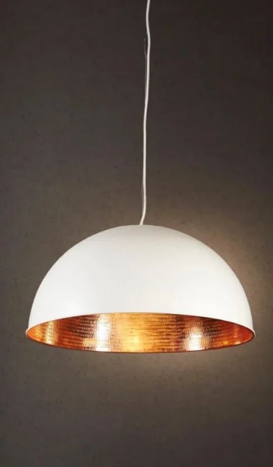Pendant light with white shade and copper interior on a dark background