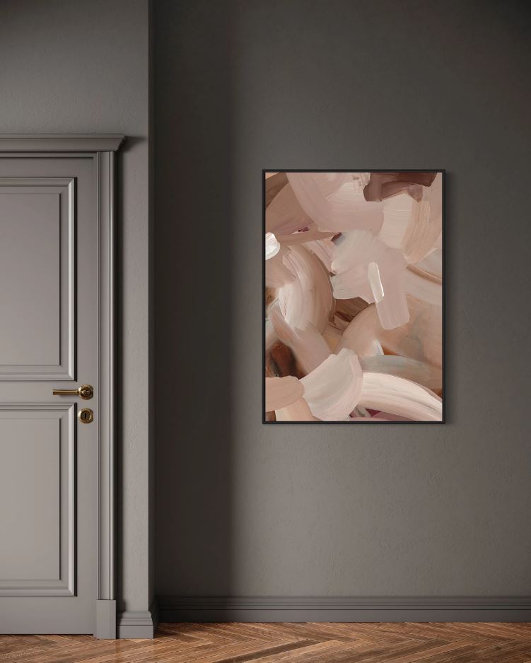 Abstract art in a frame on a grey wall next to a grey door.