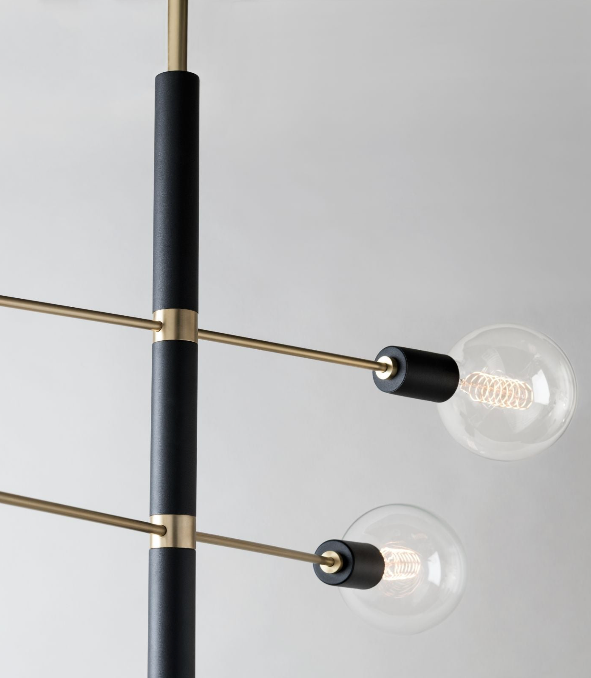 Modern chandelier with black and gold arms on a white background