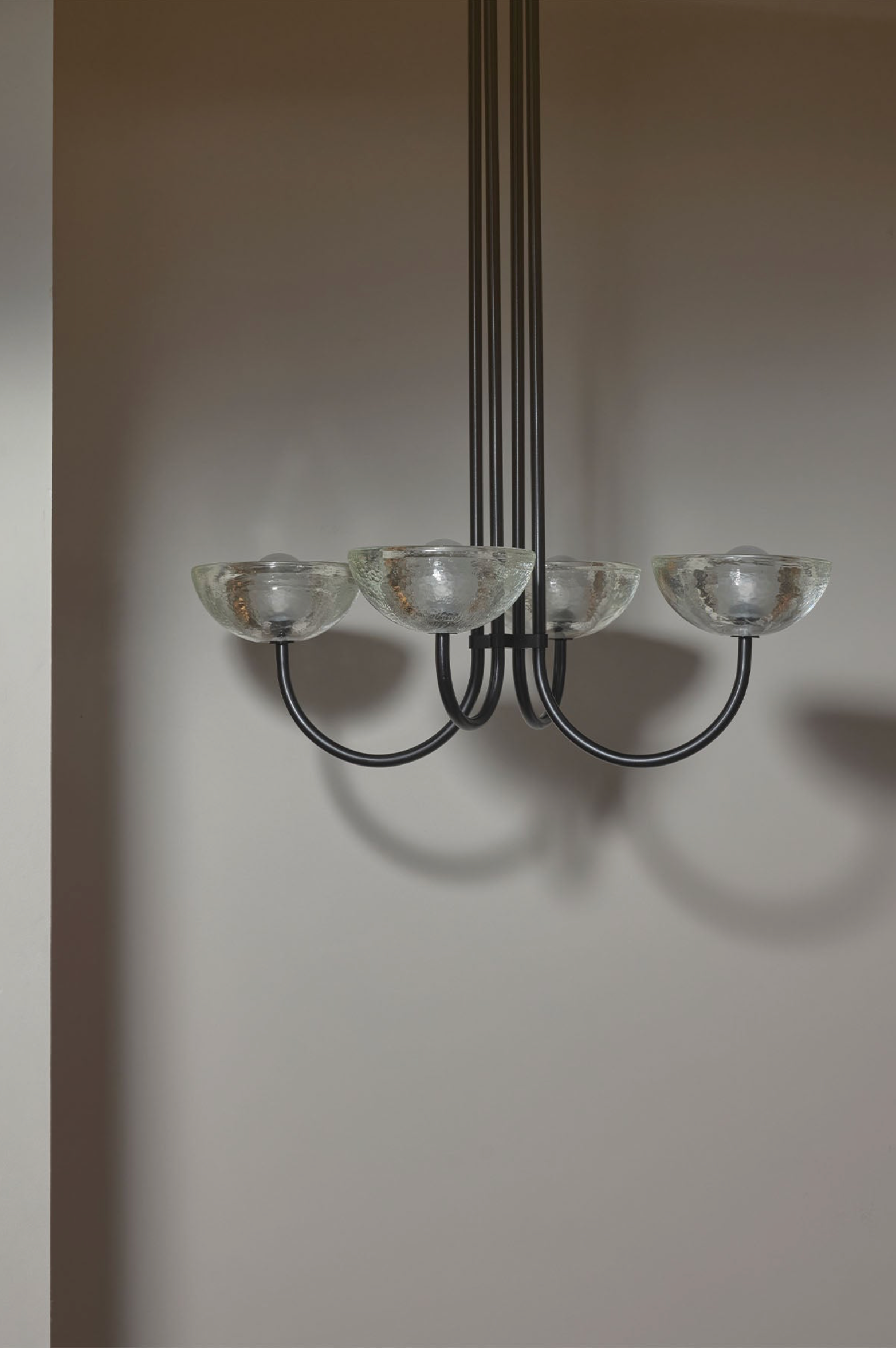Chandelier with glass shades on a plain wall