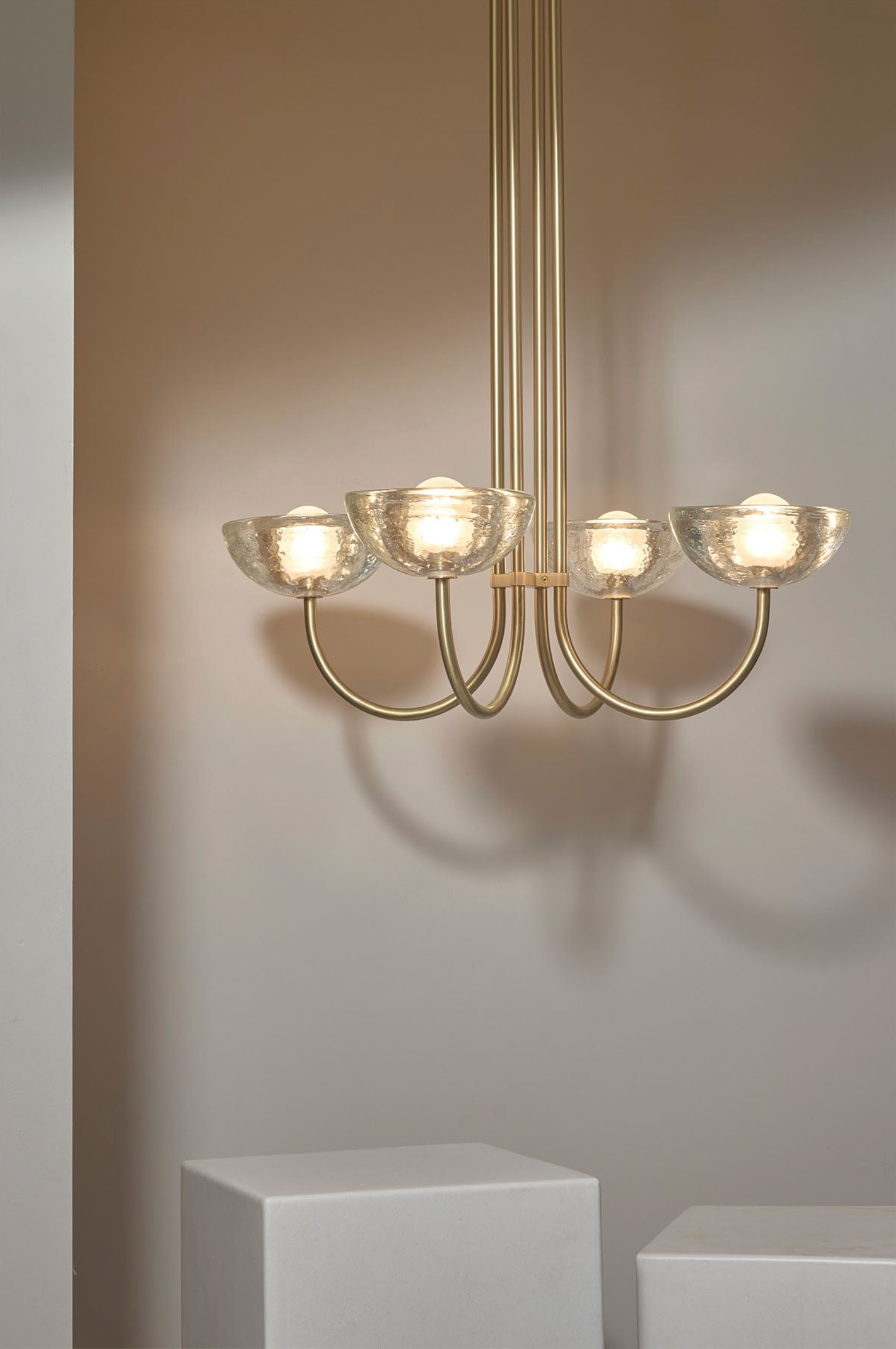 Gold chandelier with glass shades on a neutral background