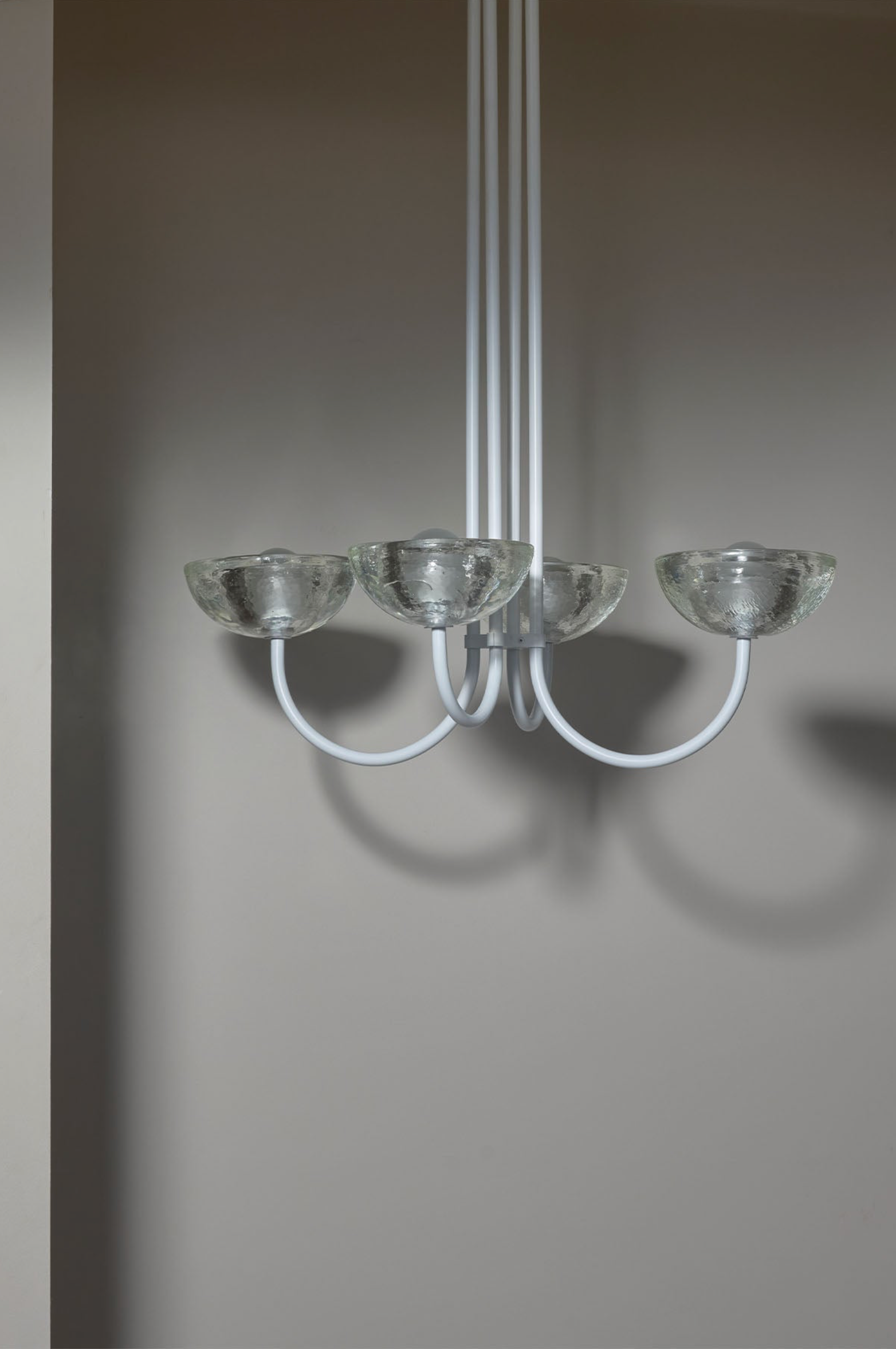 Modern chandelier with glass shades on a plain background