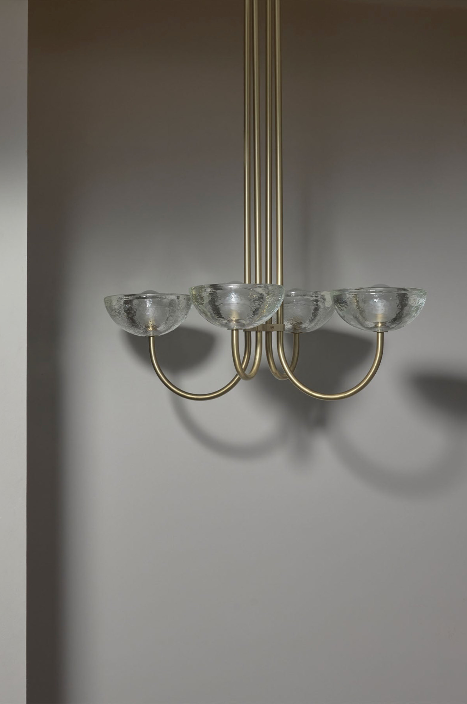 Chandelier with glass shades and gold fixtures on a plain background