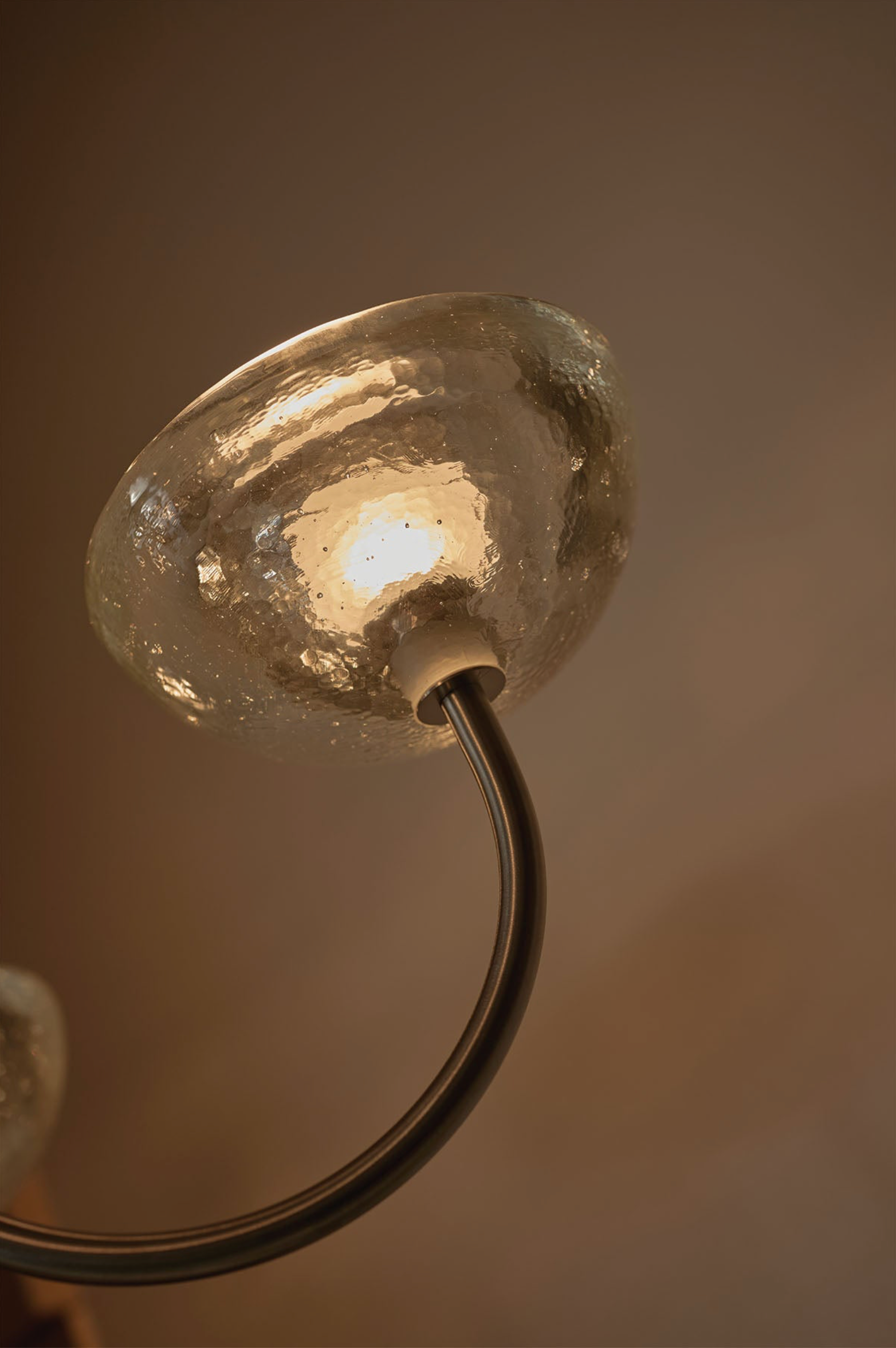 Close-up of a light fixture with a glass cover on a brown background