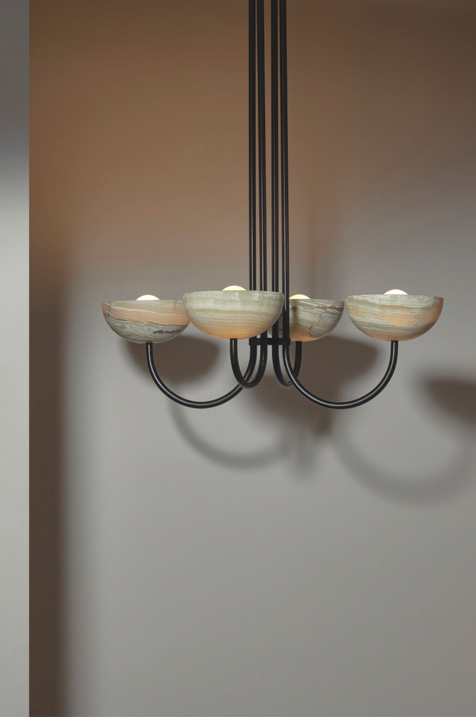 Chandelier with five bowl shaped shades on a plain background