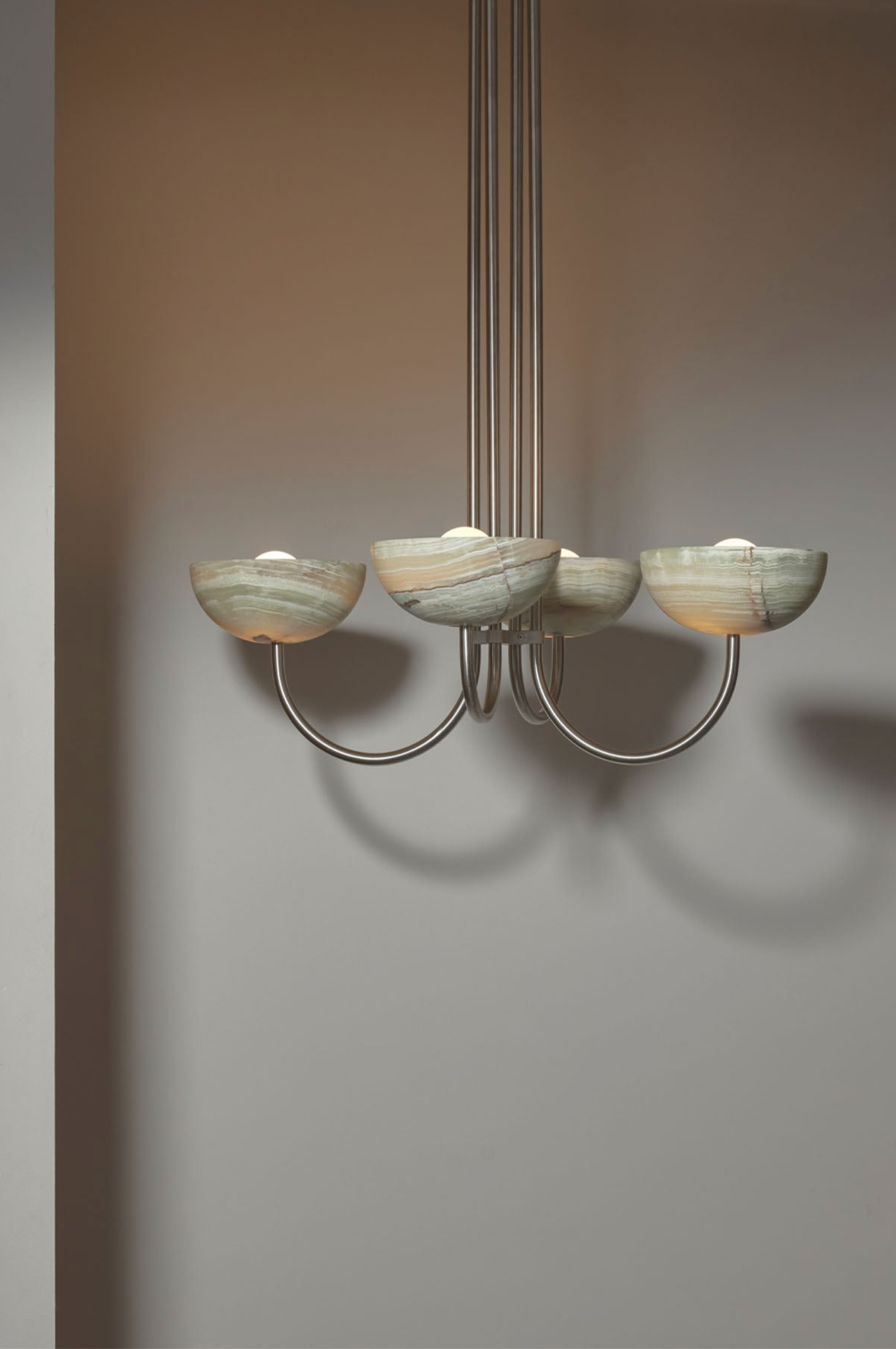 Chandelier with five bowl shaped shades on a plain background