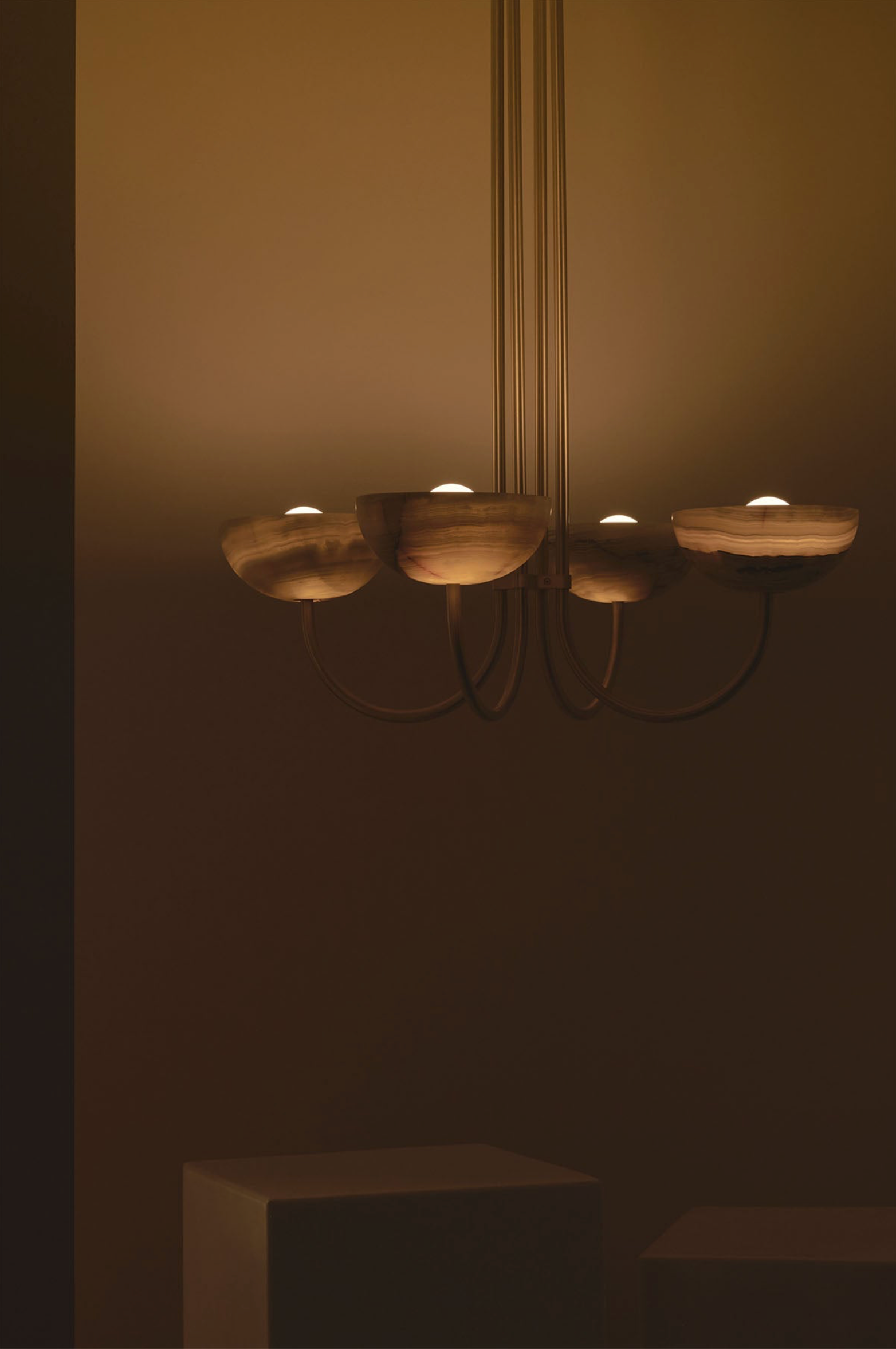 Modern chandelier with multiple light fixtures on a plain wall.