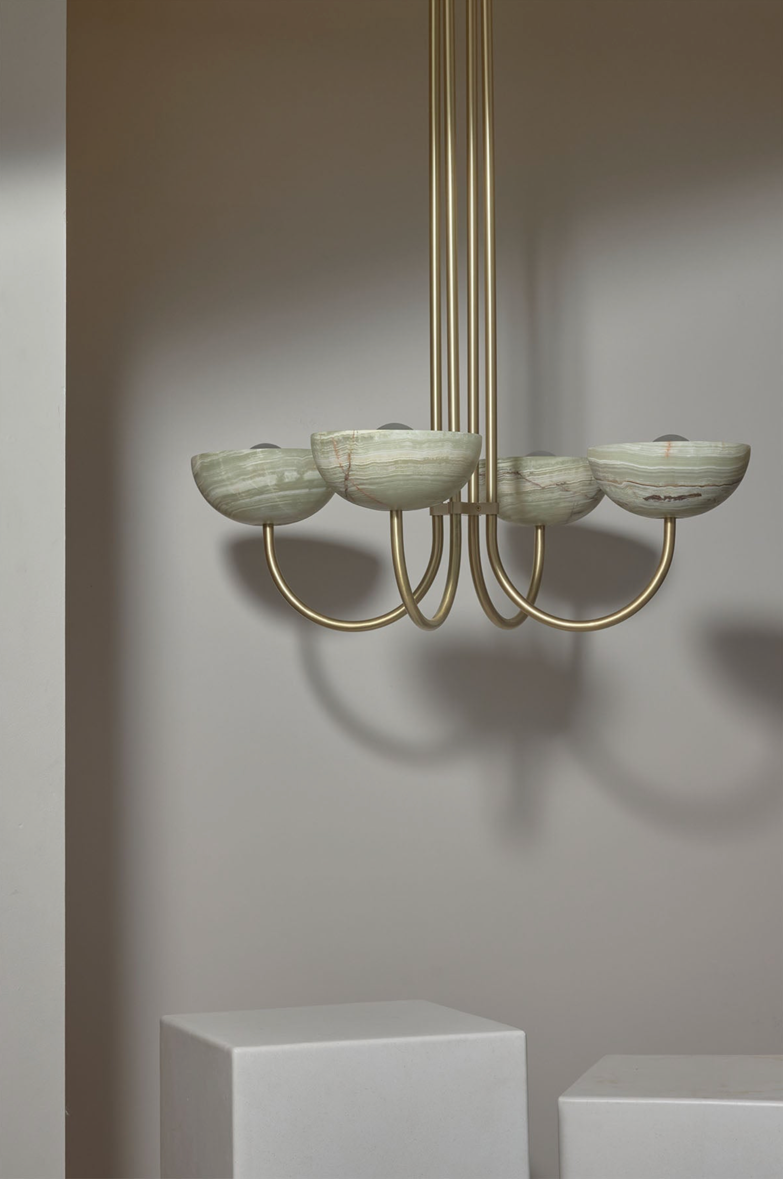 Modern chandelier with green stone shades on a neutral background