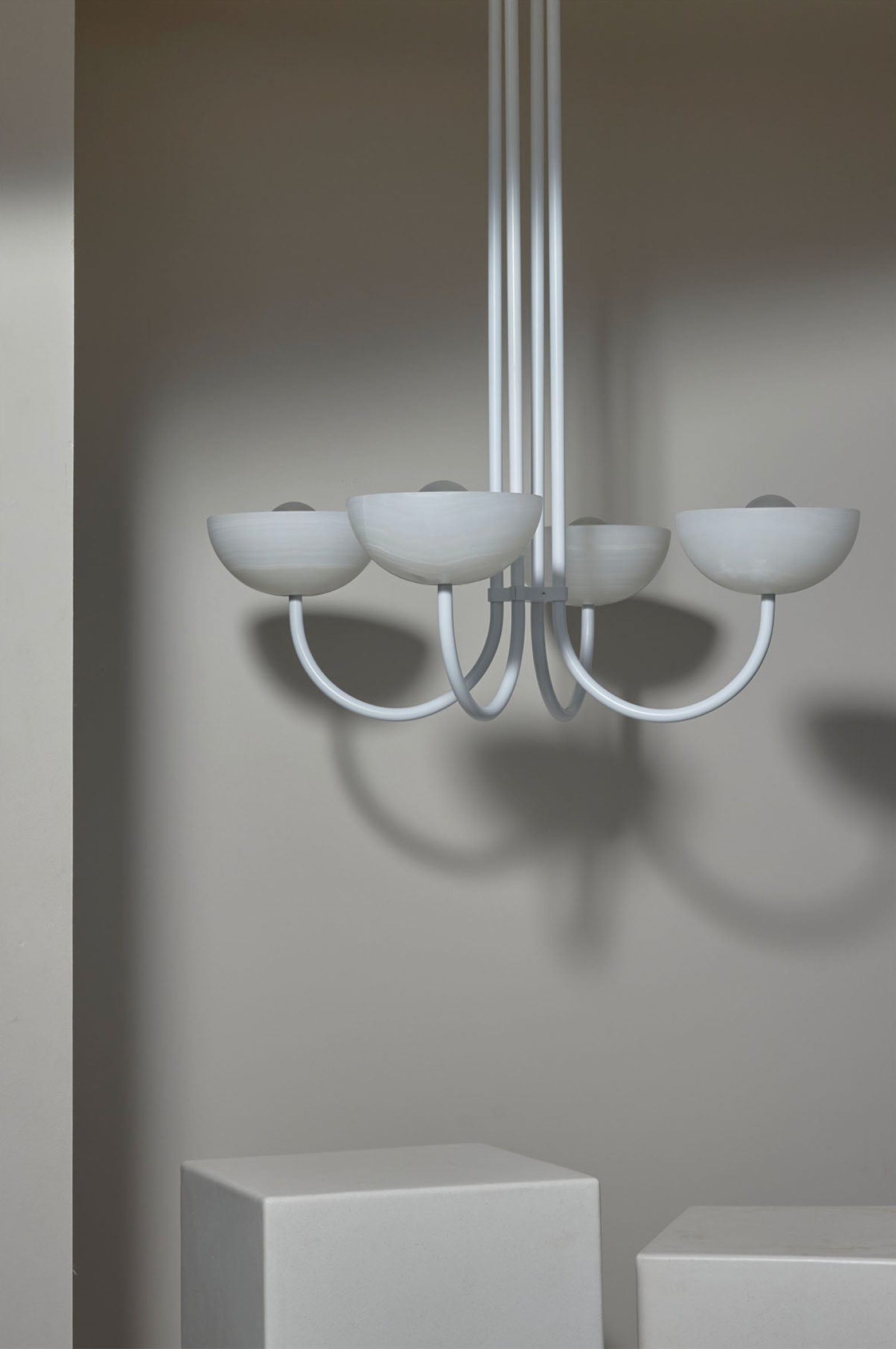 Modern chandelier with white glass shades on a neutral background