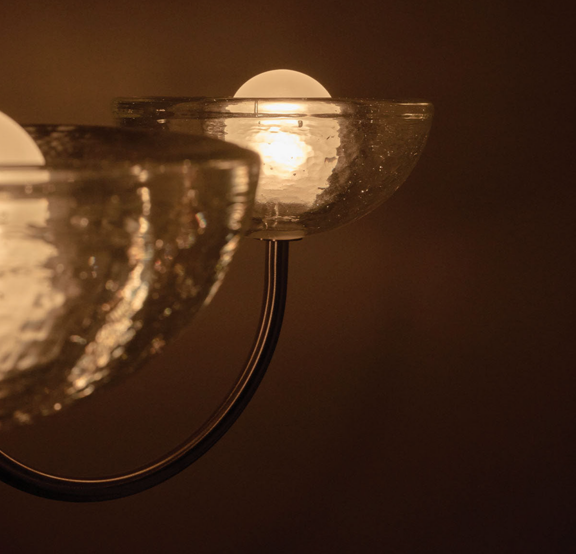 Chandelier light fixture with a warm glow on a dark background