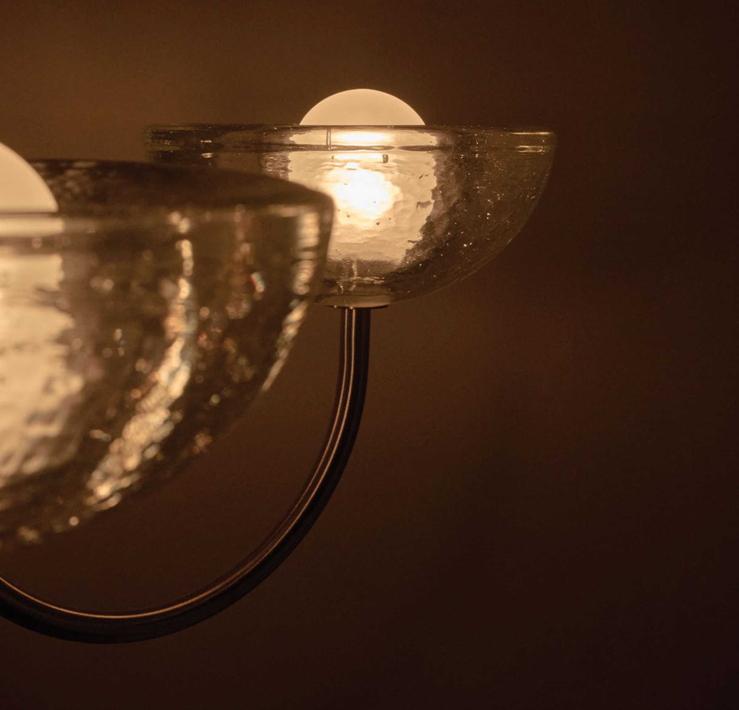 Chandelier light fixture with a warm glow on a dark background