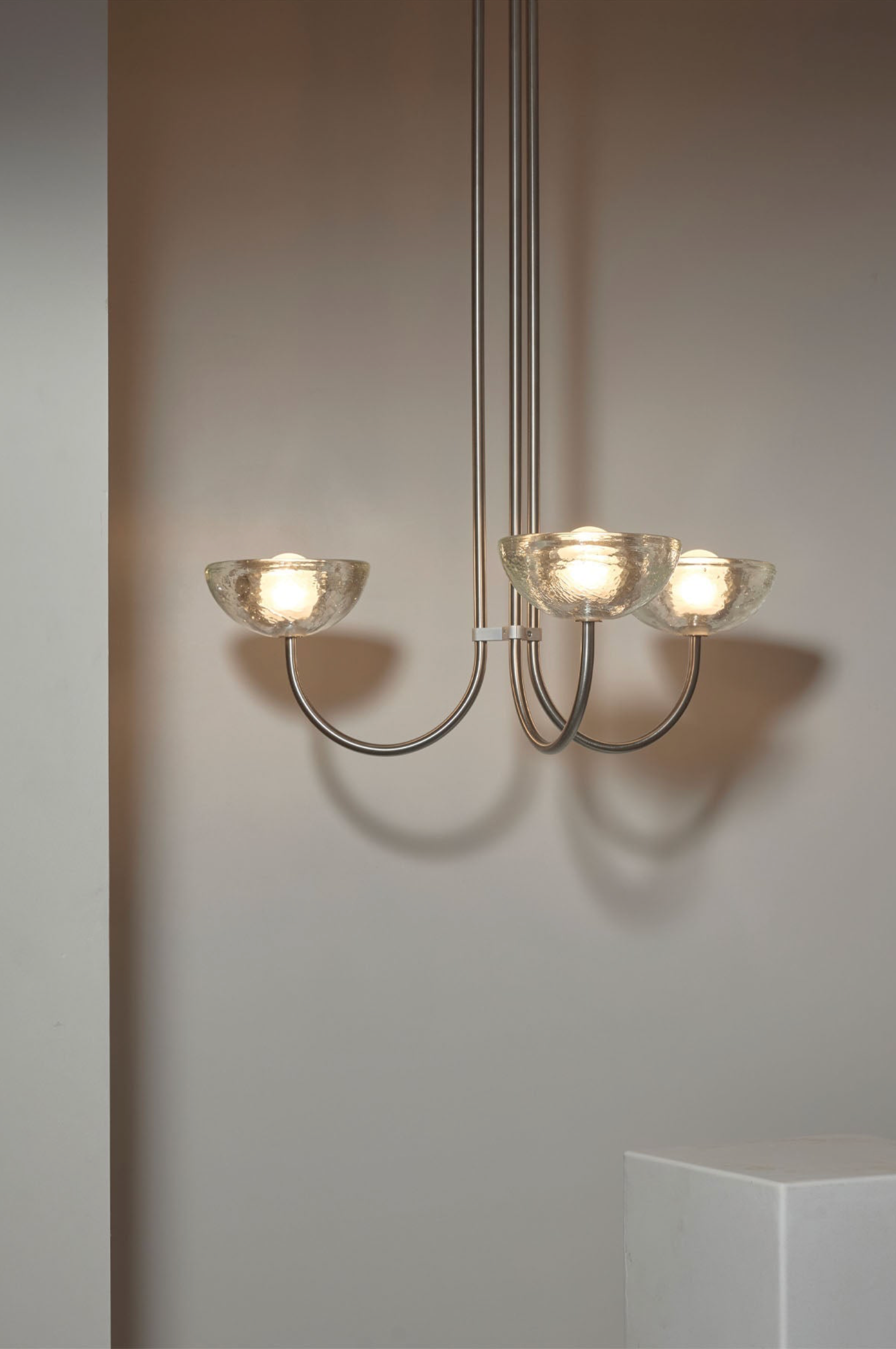 Modern chandelier with three lights on a neutral background