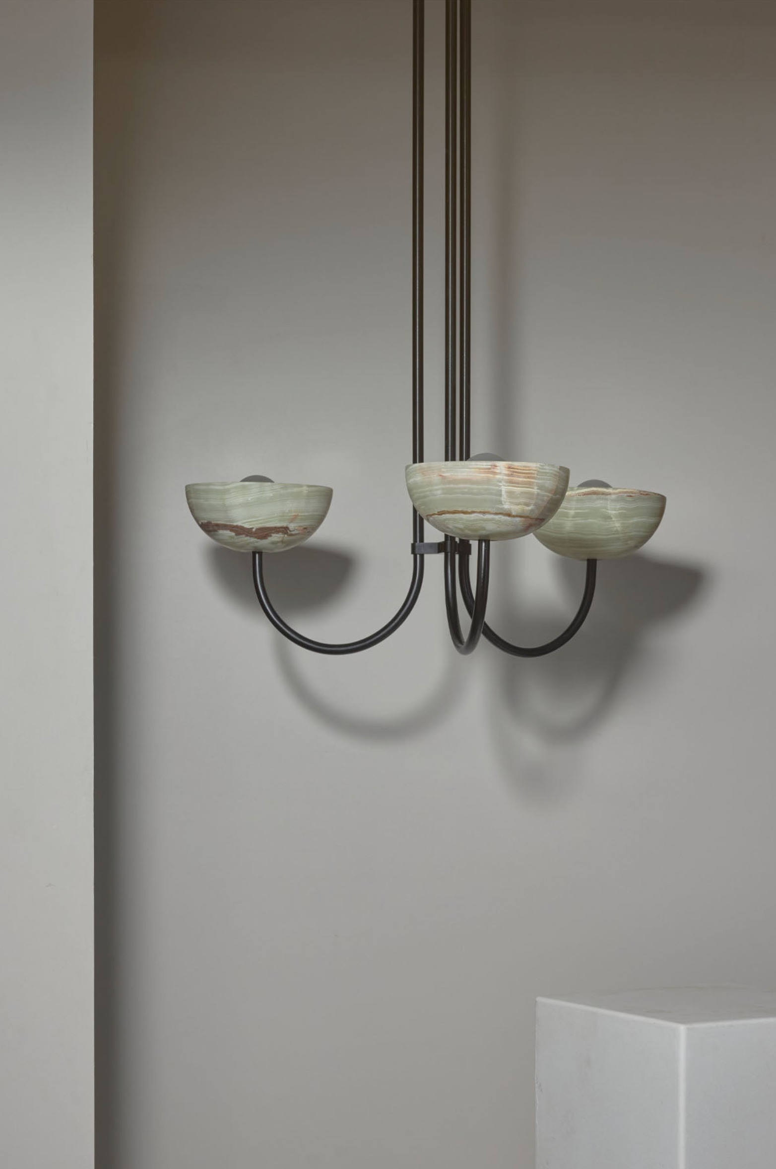 Chandelier with glass shades against a plain wall