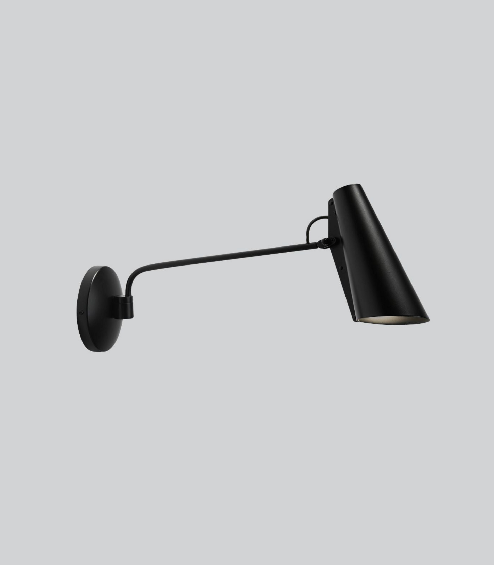 Black wall-mounted lamp on a light grey background
