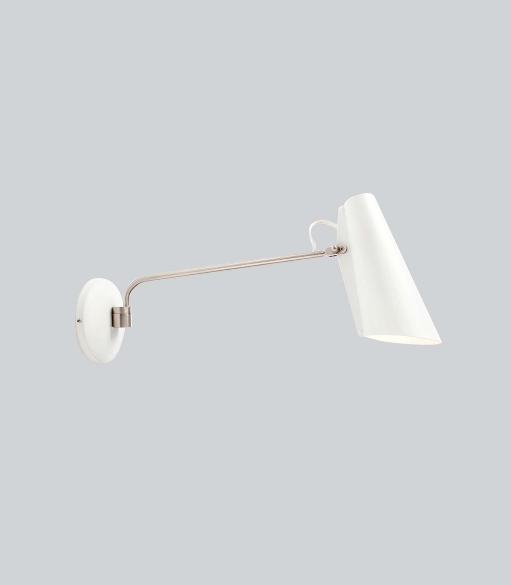 Wall-mounted lamp with a white shade and metallic arm on a light gray background