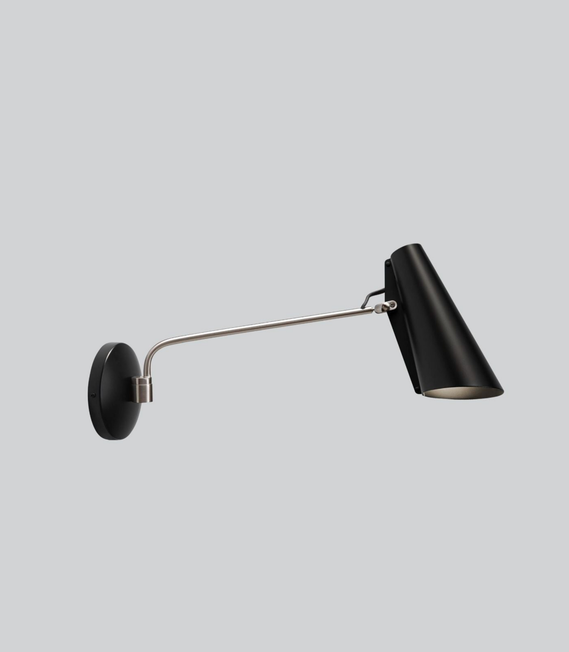 Black wall lamp with a long arm on a light gray background