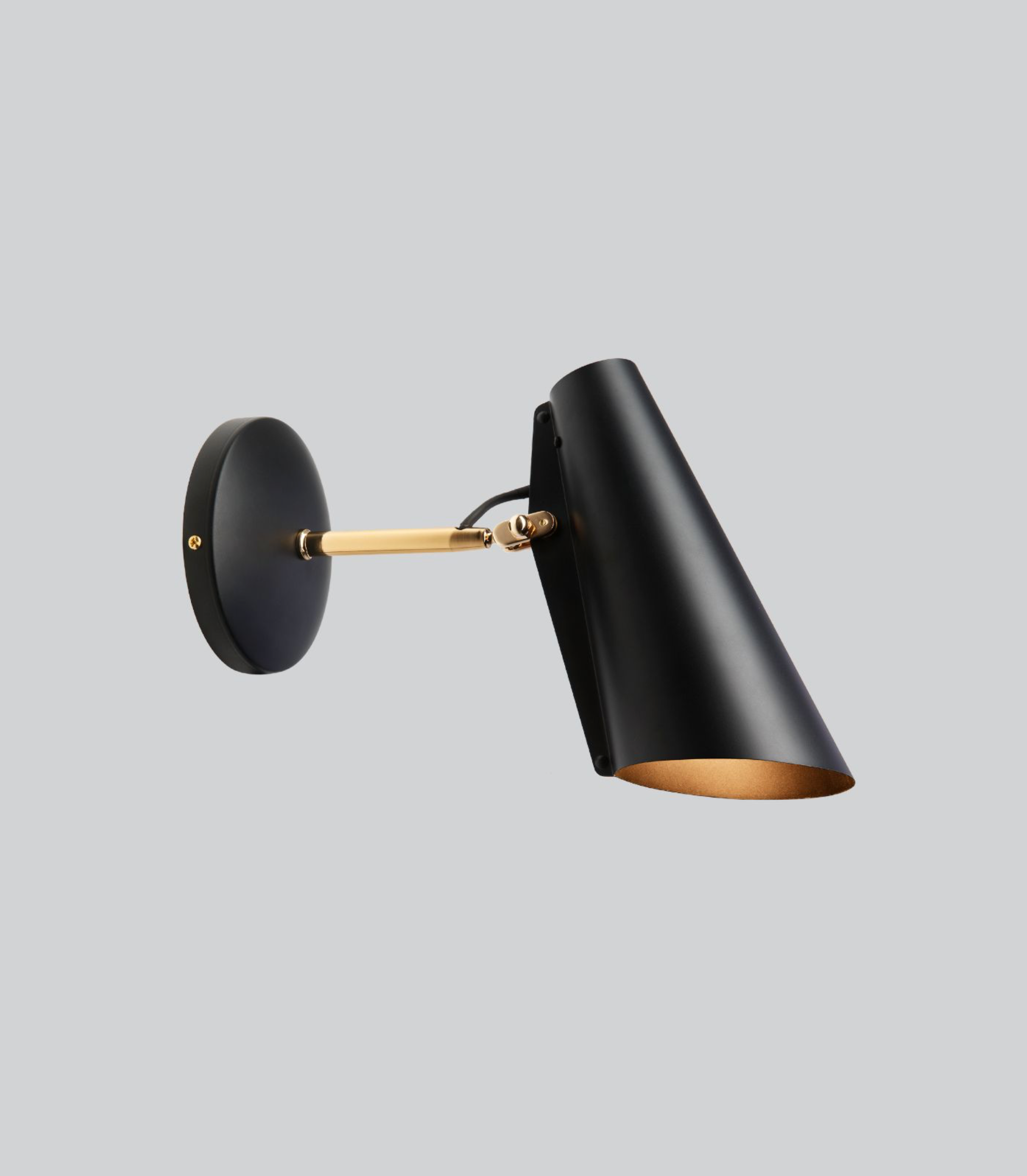 Black wall lamp with gold accent on a light gray background