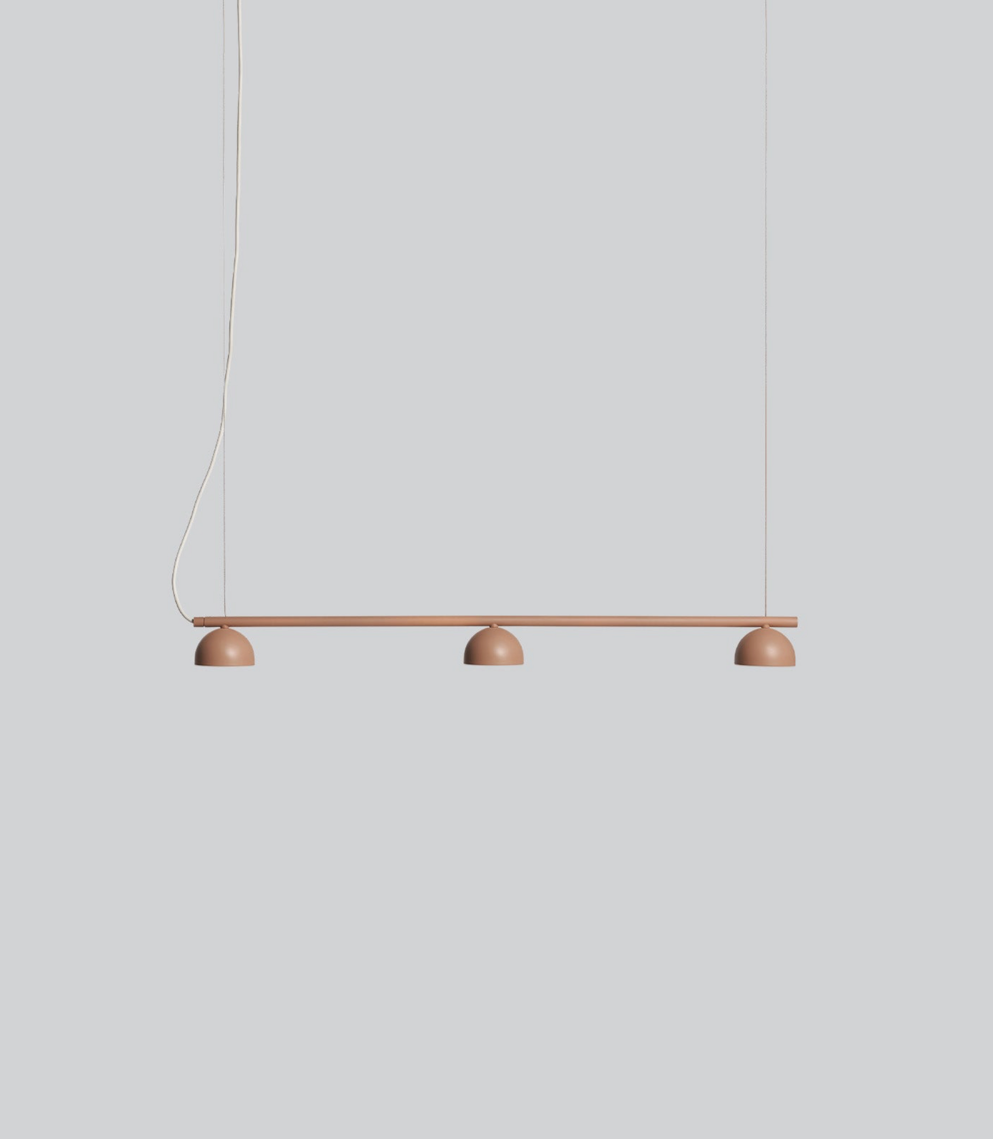 Modern pendant light with three round lights on a neutral background