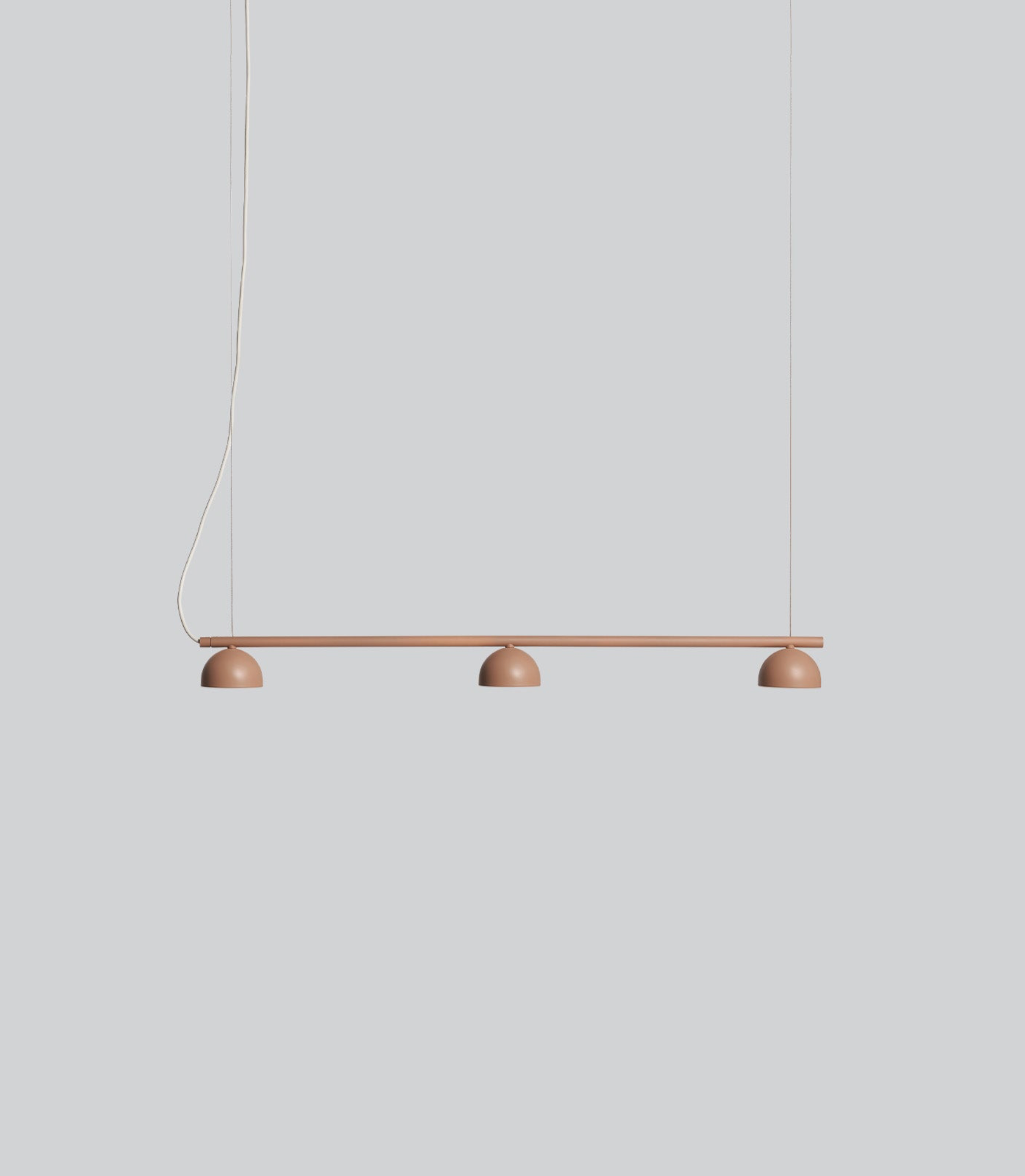 Modern pendant light with three round lights on a neutral background
