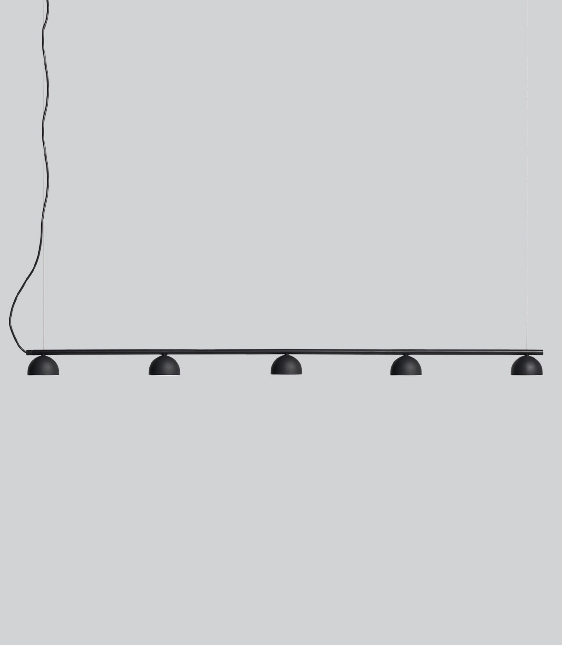 Modern pendant light with five black lampshades on a grey background