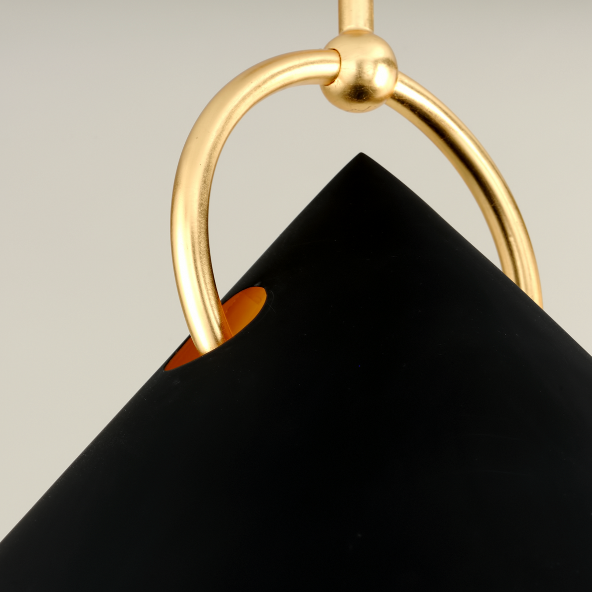 Black pendant with a gold ring detail on a neutral background