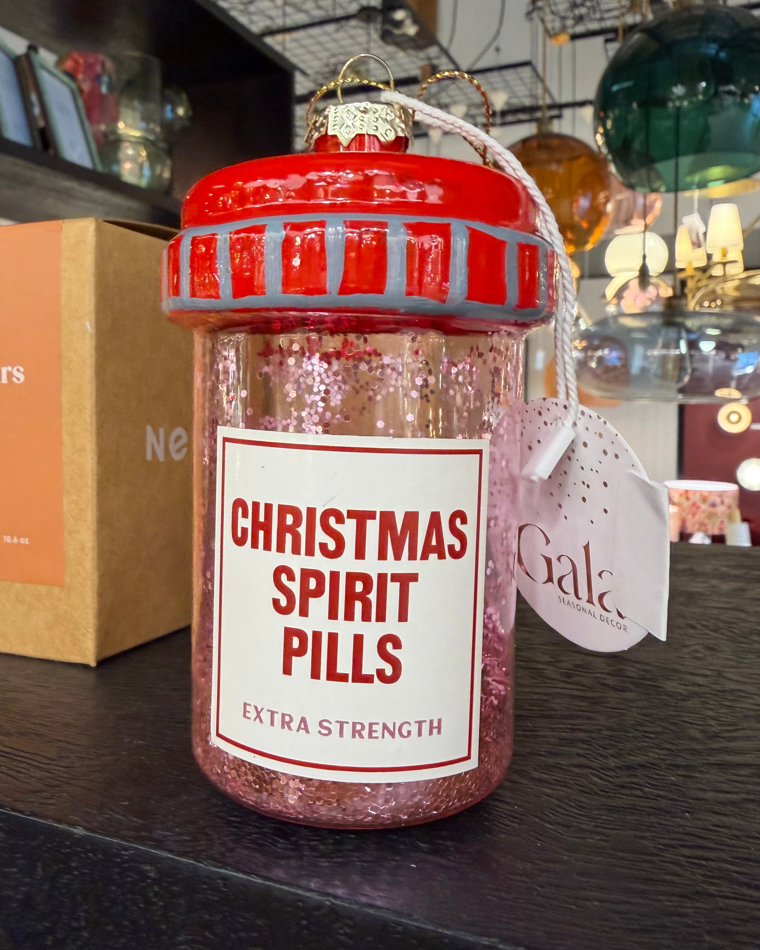 Decorative bottle labeled 'Christmas Spirit Pills' on a shelf with a blurred background