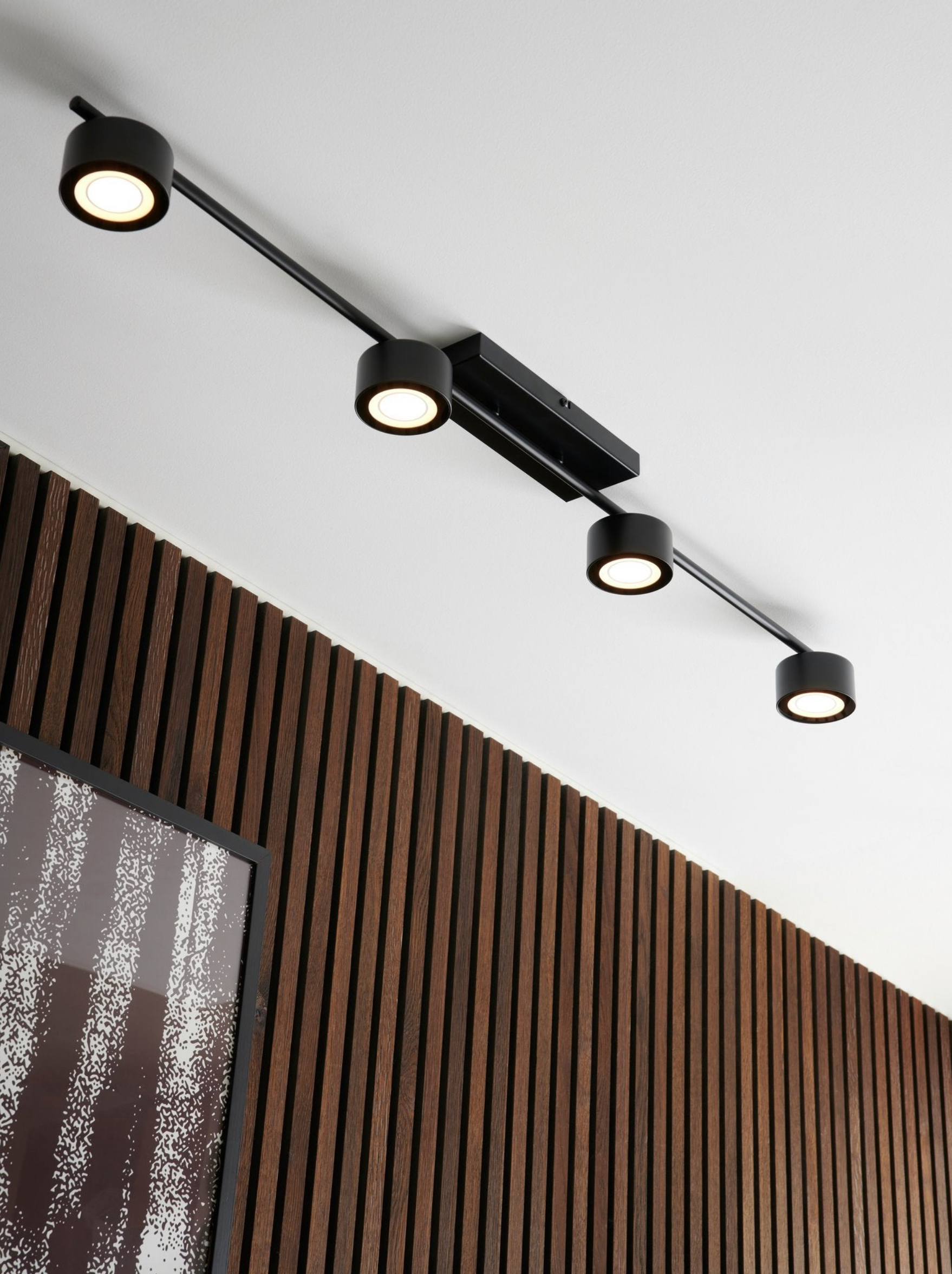 Modern ceiling light fixture with three lights on a white ceiling.