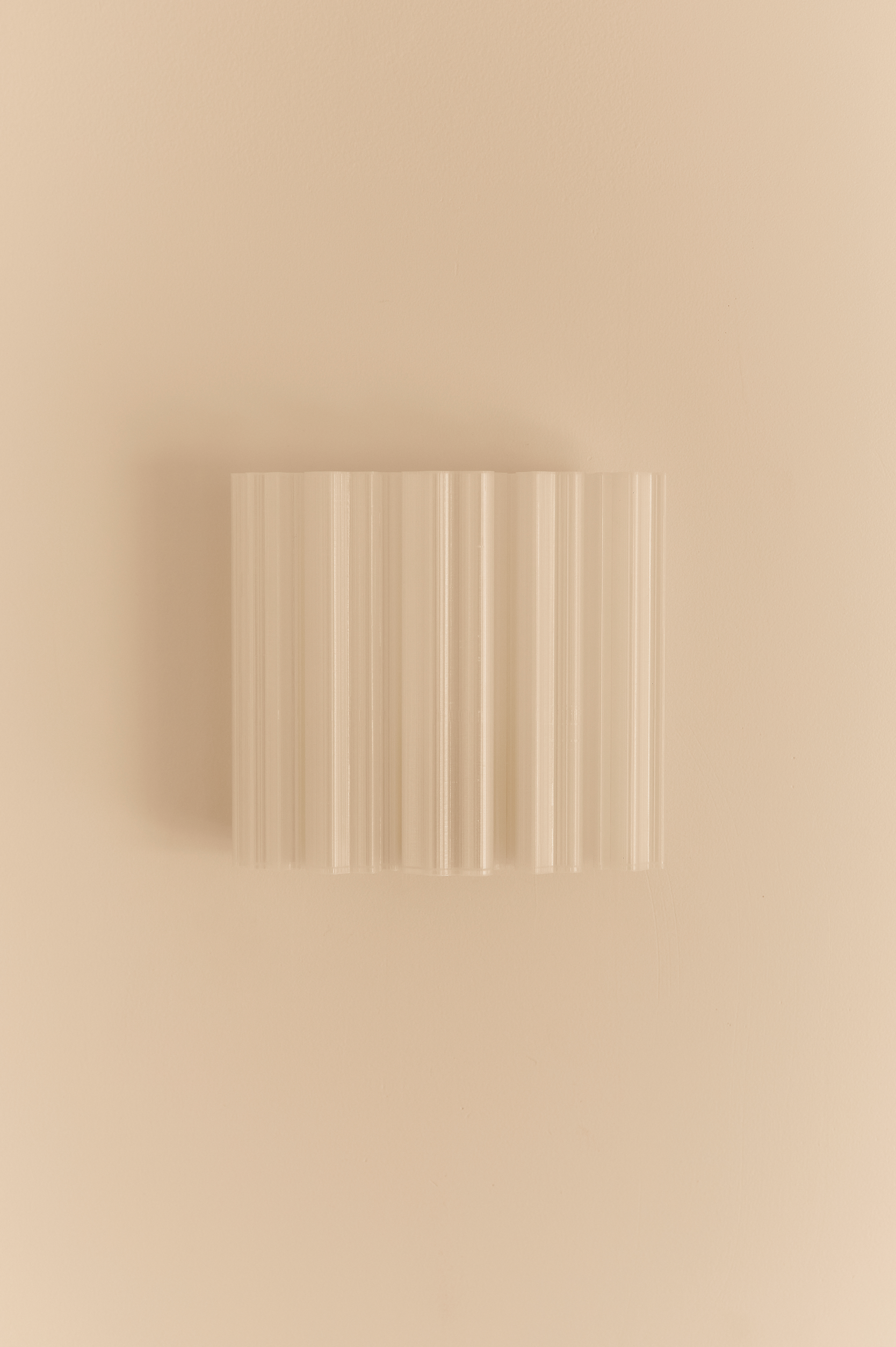 Rectangular 3D printed wall light fixture on a beige background