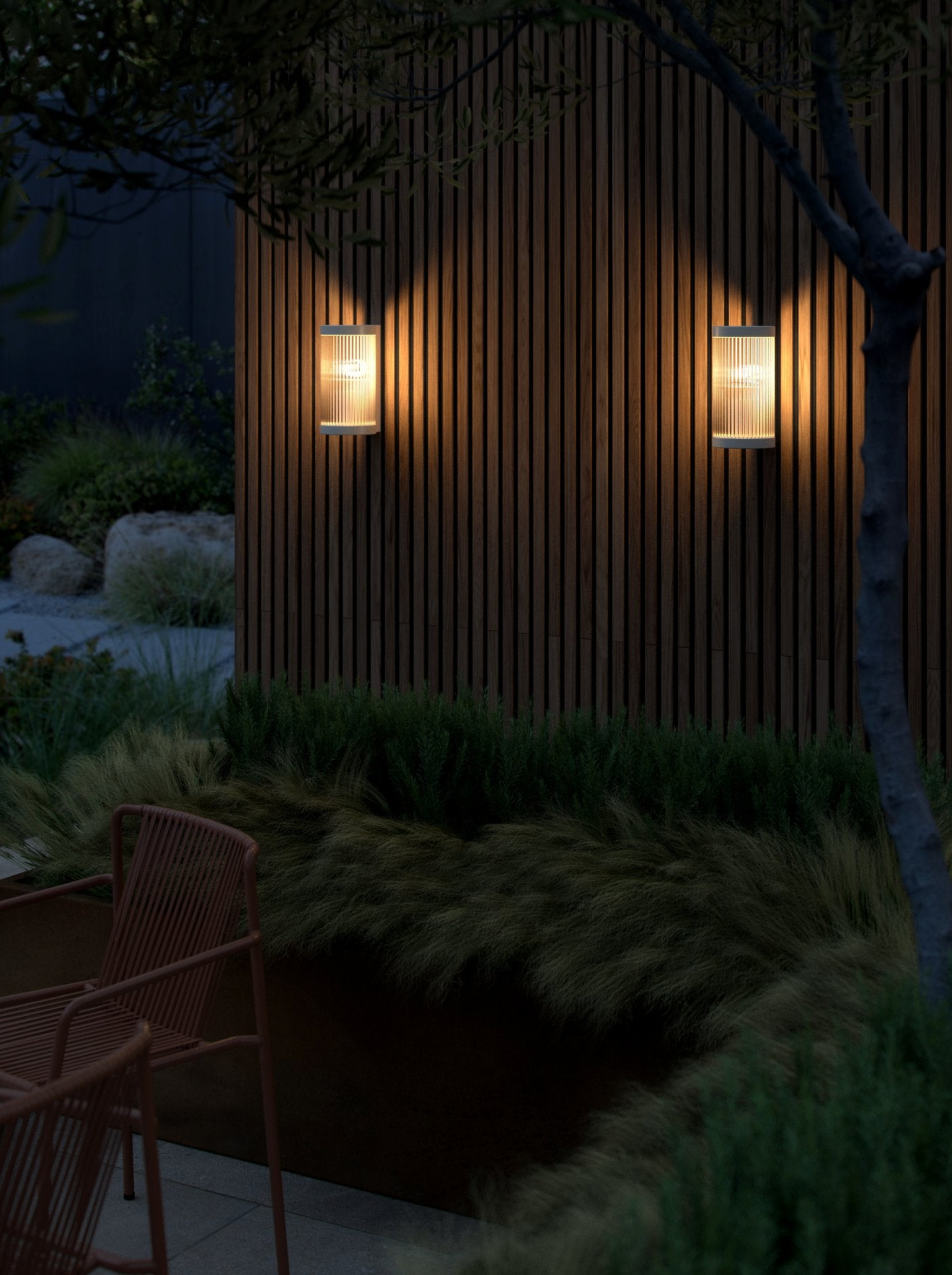 Wooden wall with two illuminated outdoor lights in a garden setting