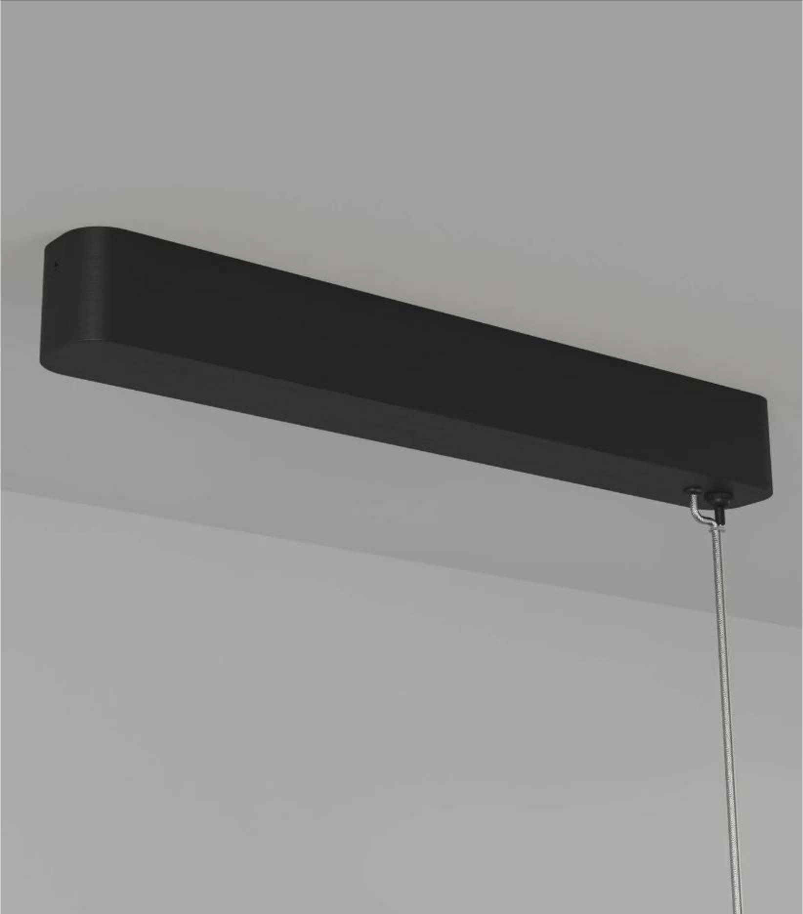 Black rectangular pendant light fixture on a grey background