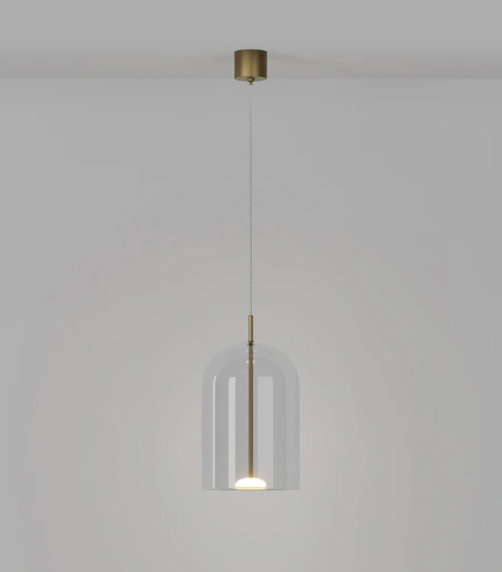 Modern pendant light with glass shade and brass fixture on a plain background