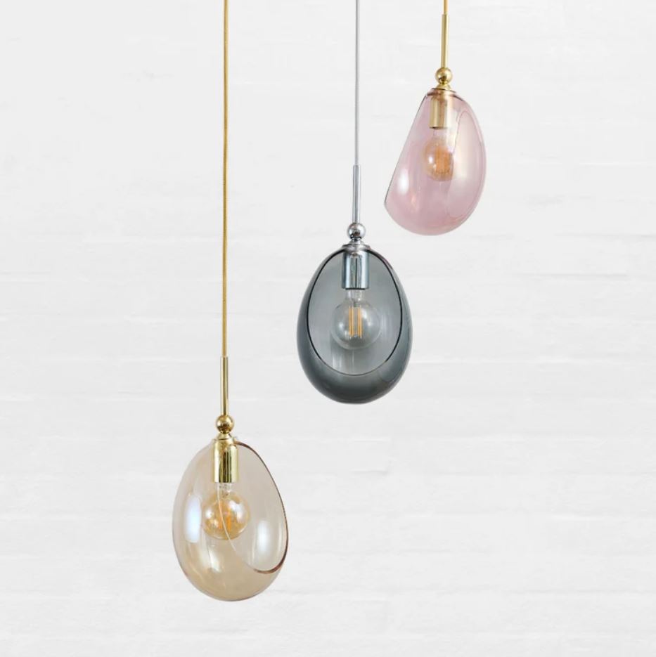 Three hanging pendant lights with different colored glass shades on a white background