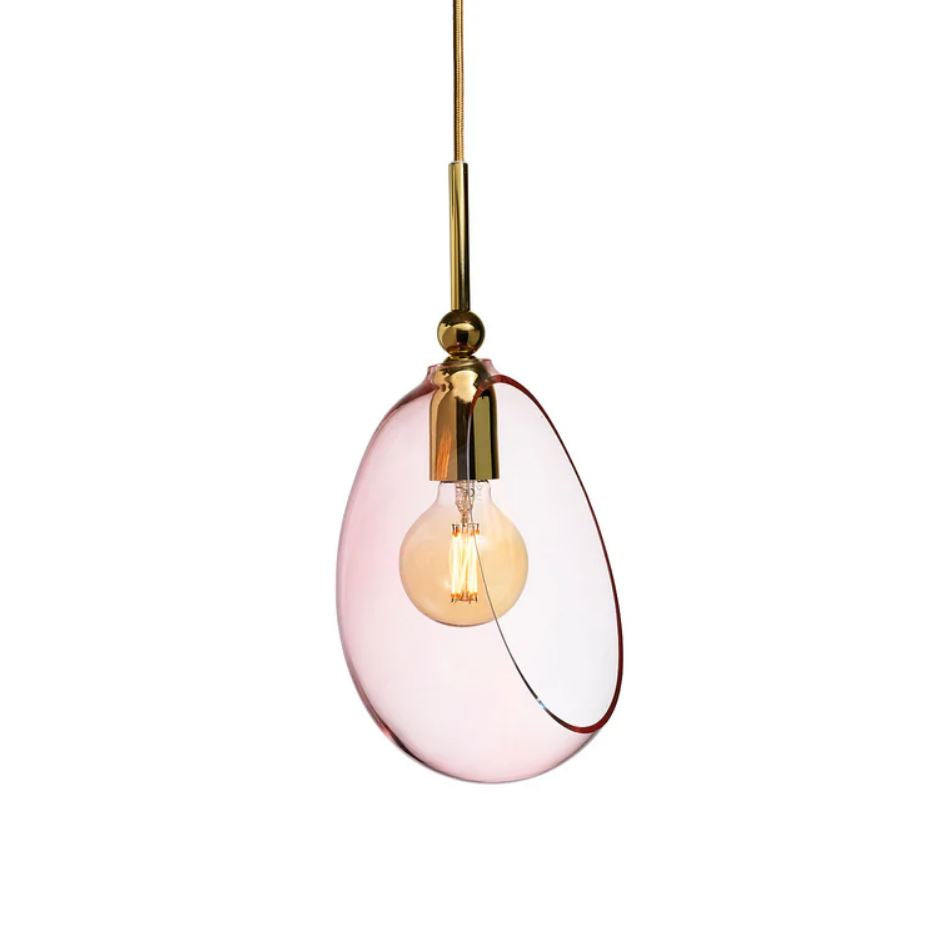 Pendant light with pink glass shade and gold fixture on a white background