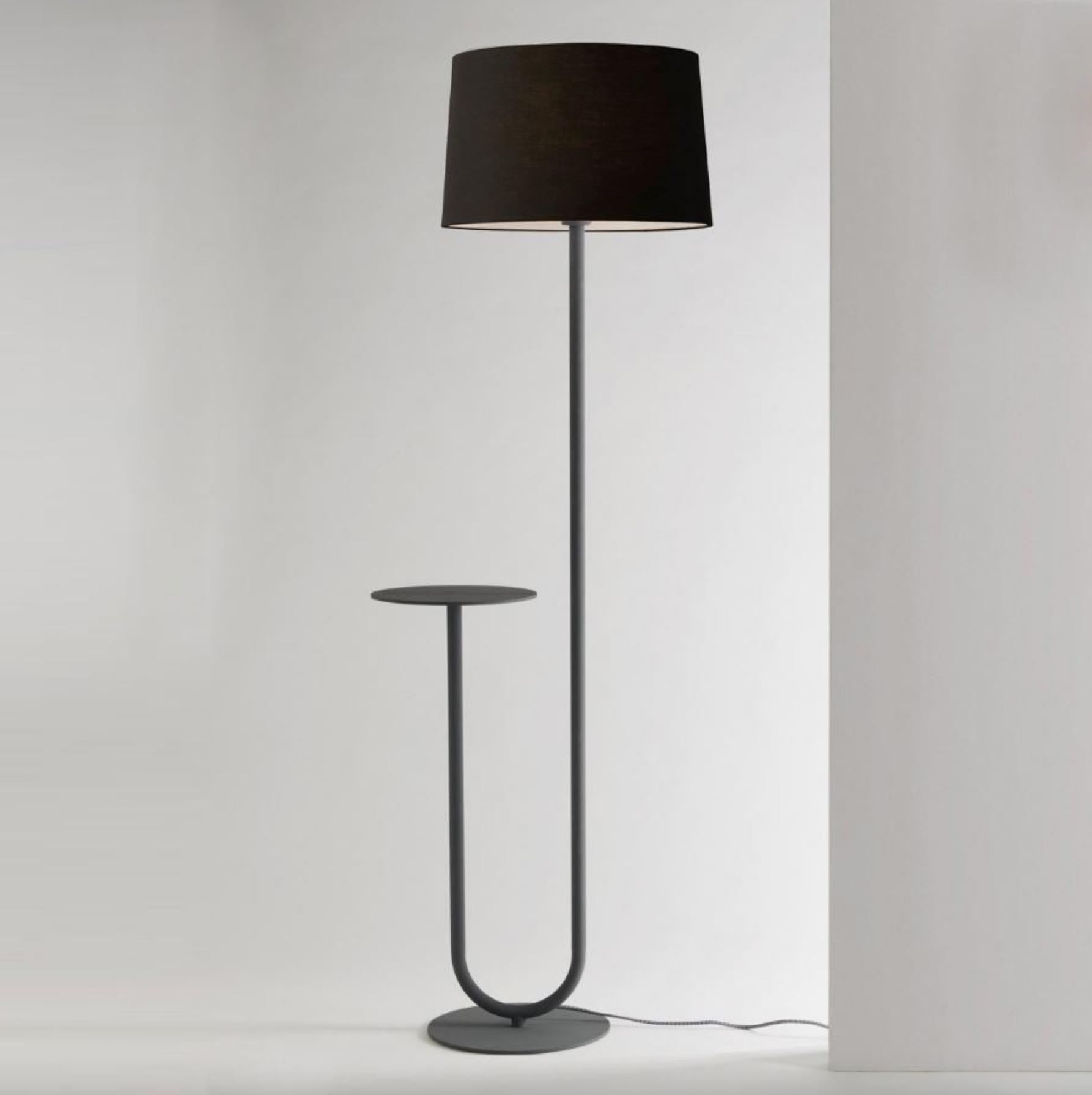Black floor lamp with a cylindrical shade on a white background