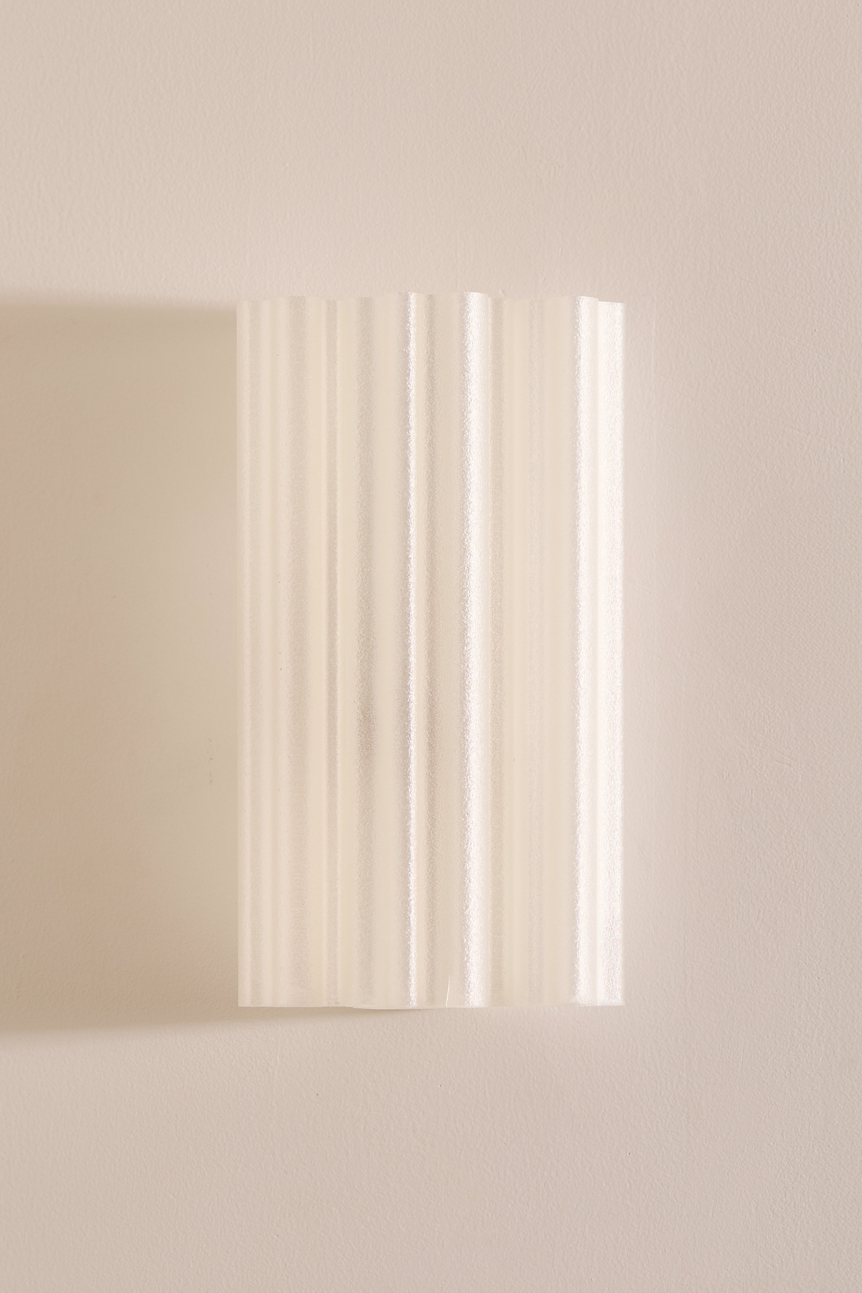 Rectangular 3D printed wall light fixture on a beige wall