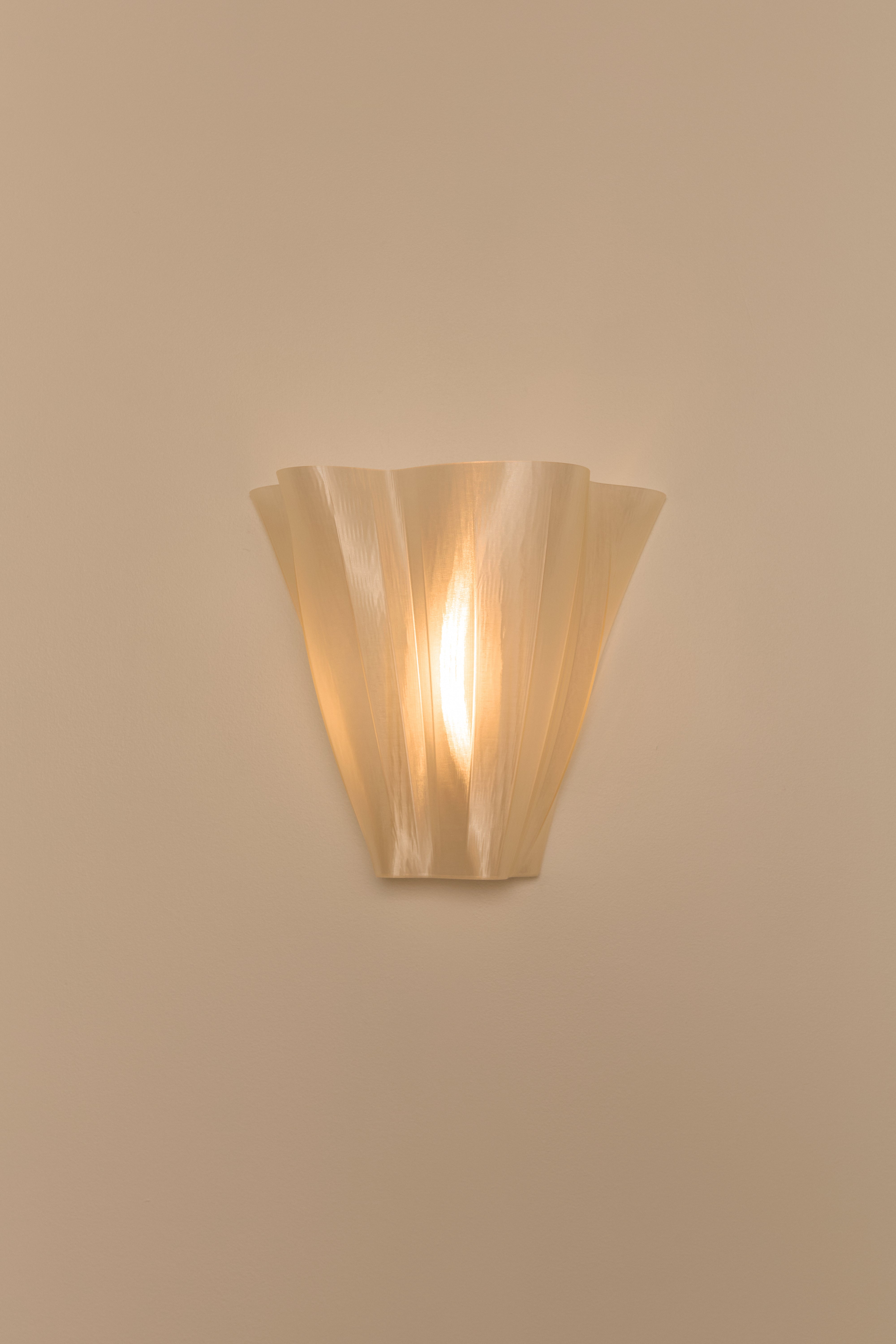 Wall-mounted 3D printed wall light fixture on a beige wall.