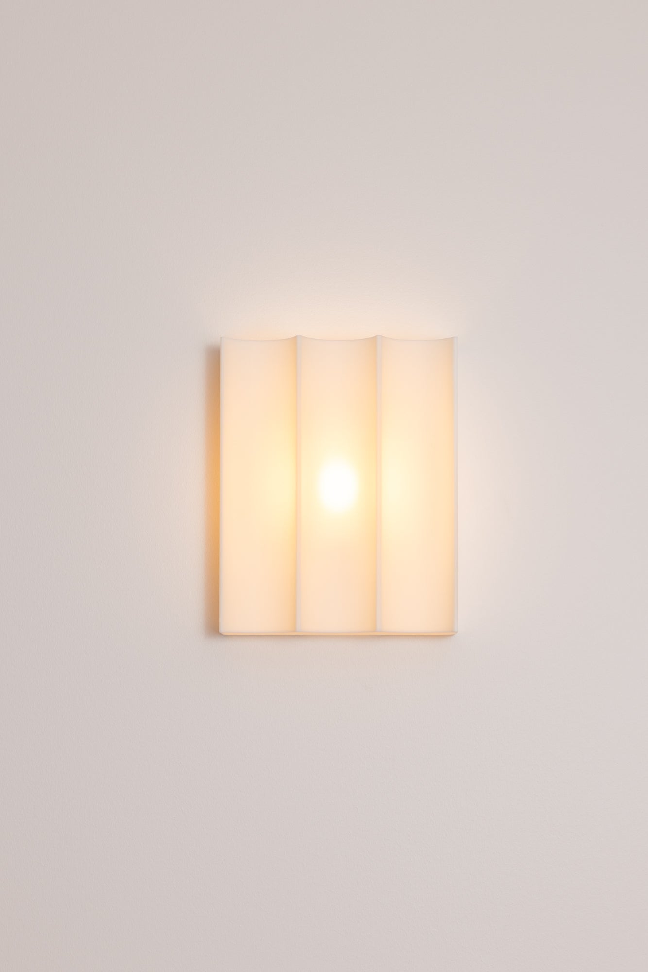 Wall-mounted 3D printed wall light fixture on a plain wall