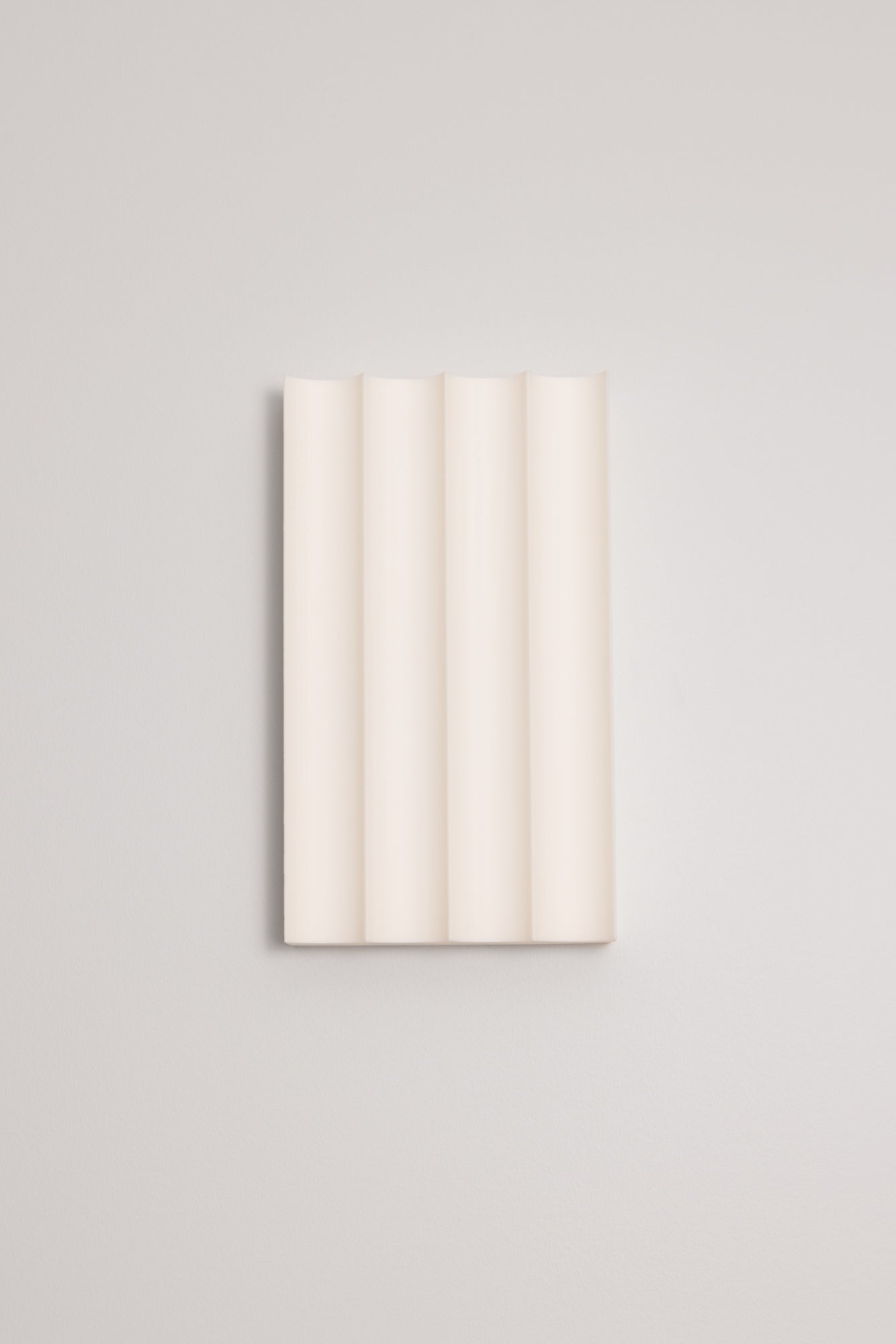 Rectangular 3D printed wall light with vertical slats on a light grey background