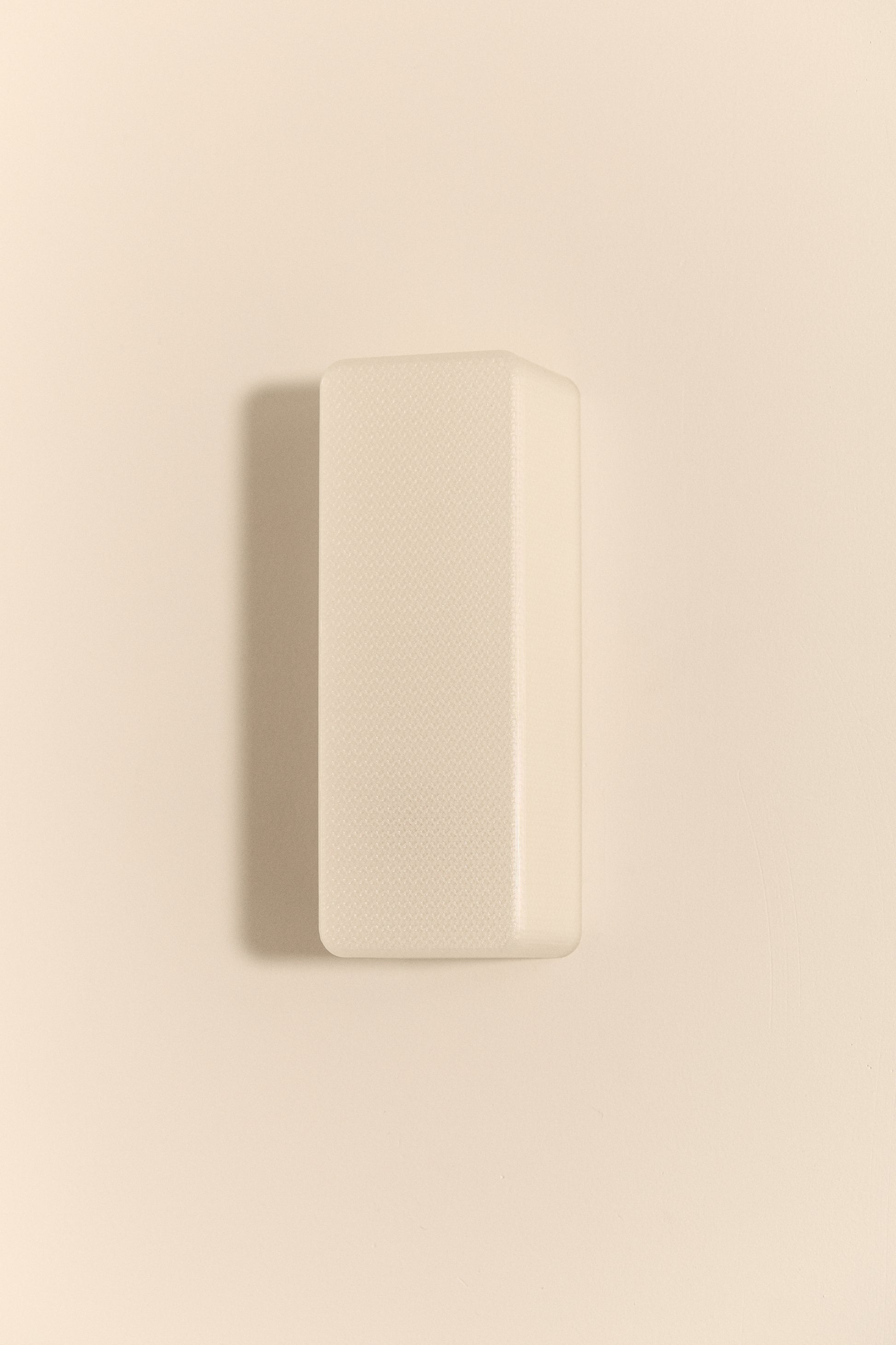 Rectangular 3D printed wall light on a beige wall