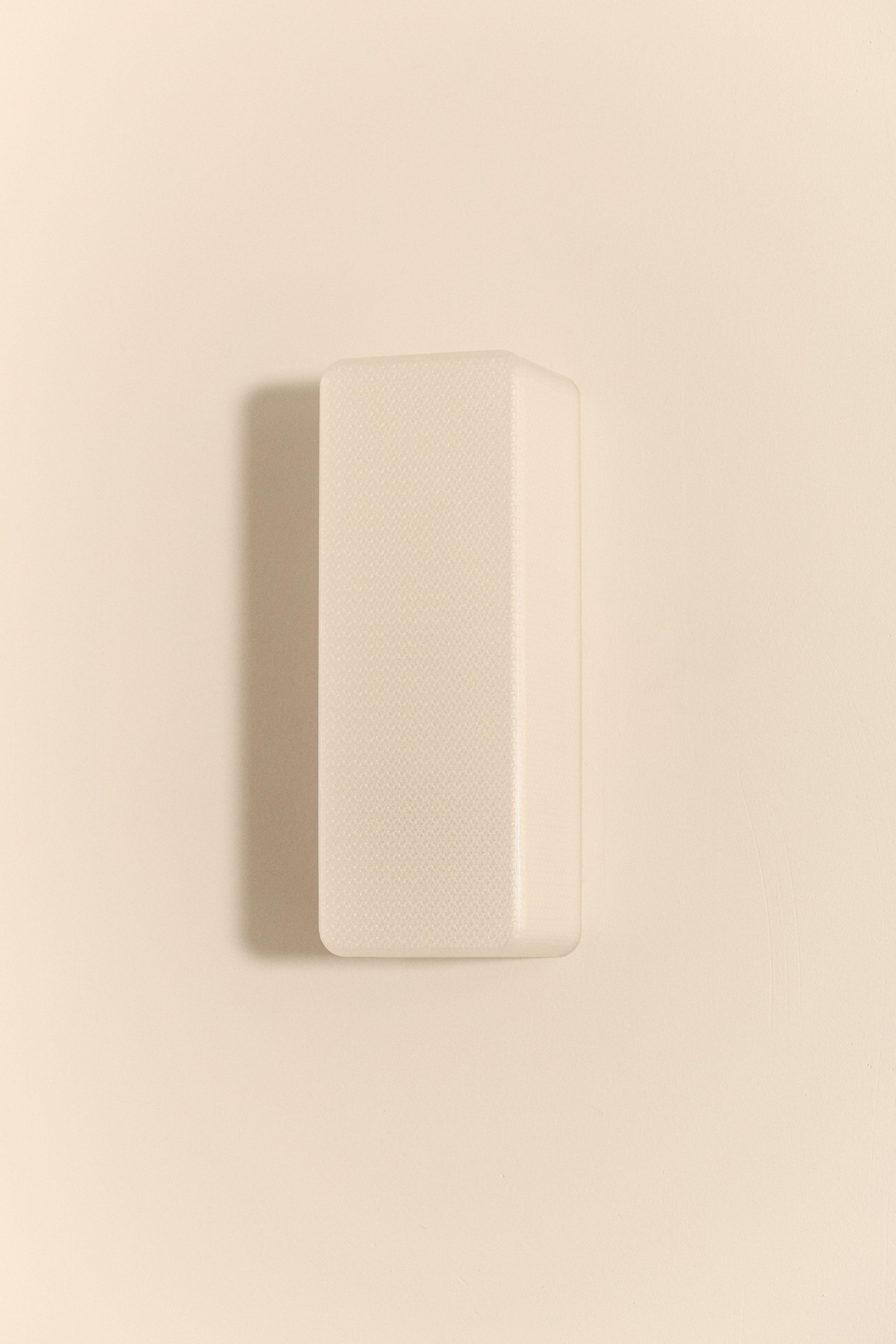 Rectangular 3D printed wall light on a beige wall