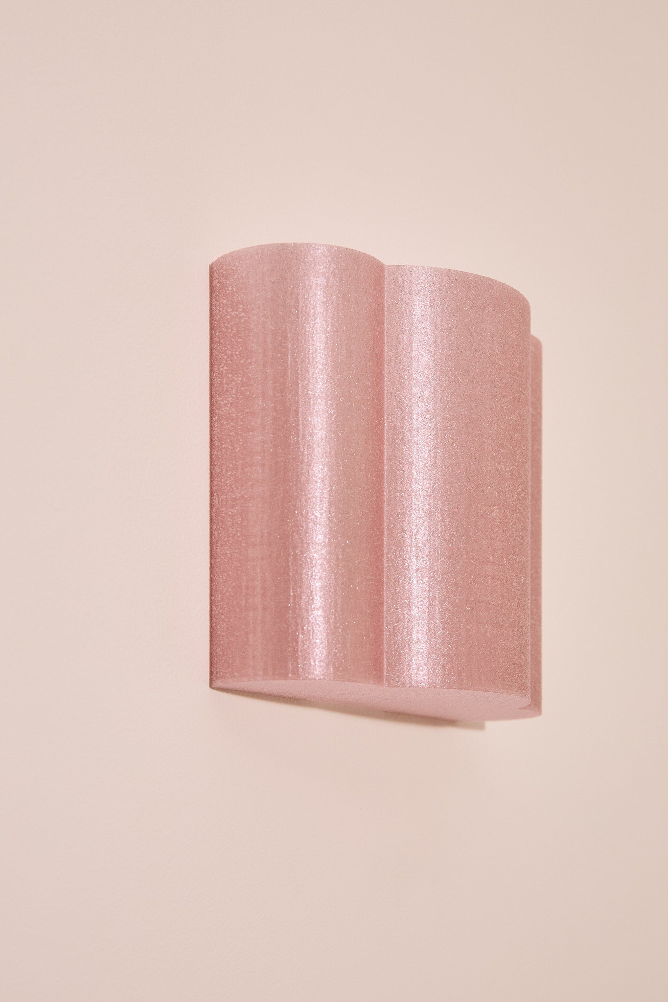 Pink textured 3D printed wall lightt on a beige background
