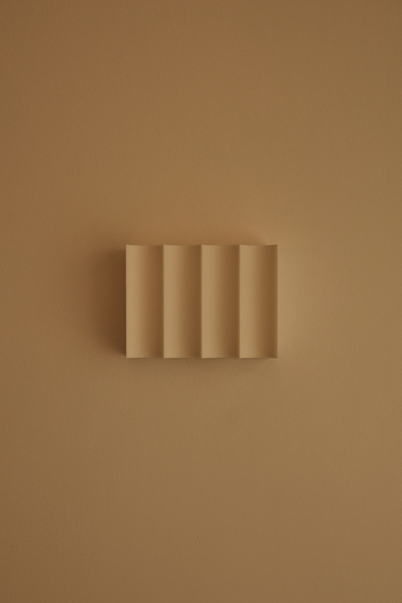 3D printed wall light on a matching beige wall.