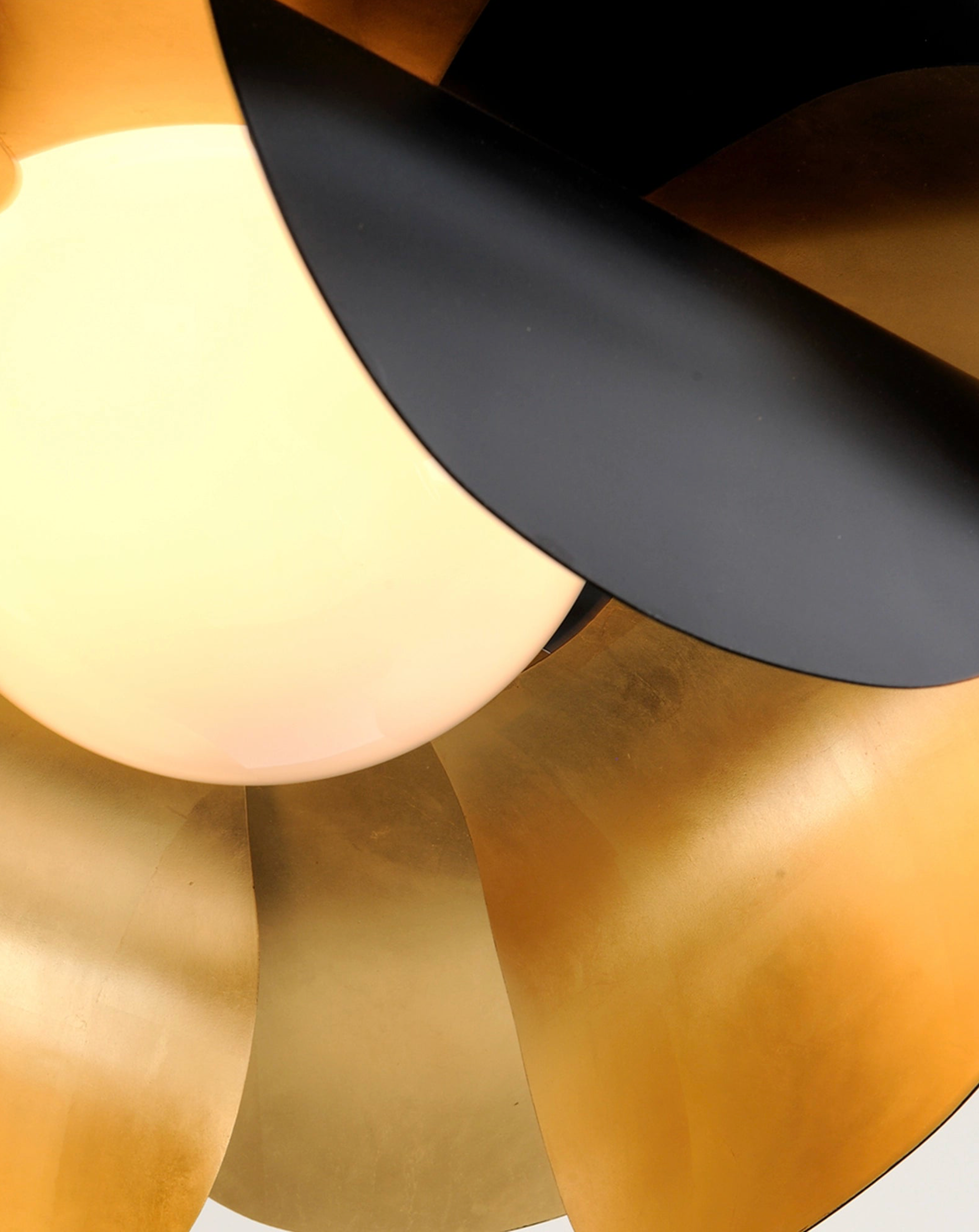Close-up of a ceiling light fixture with black, gold, and white components.
