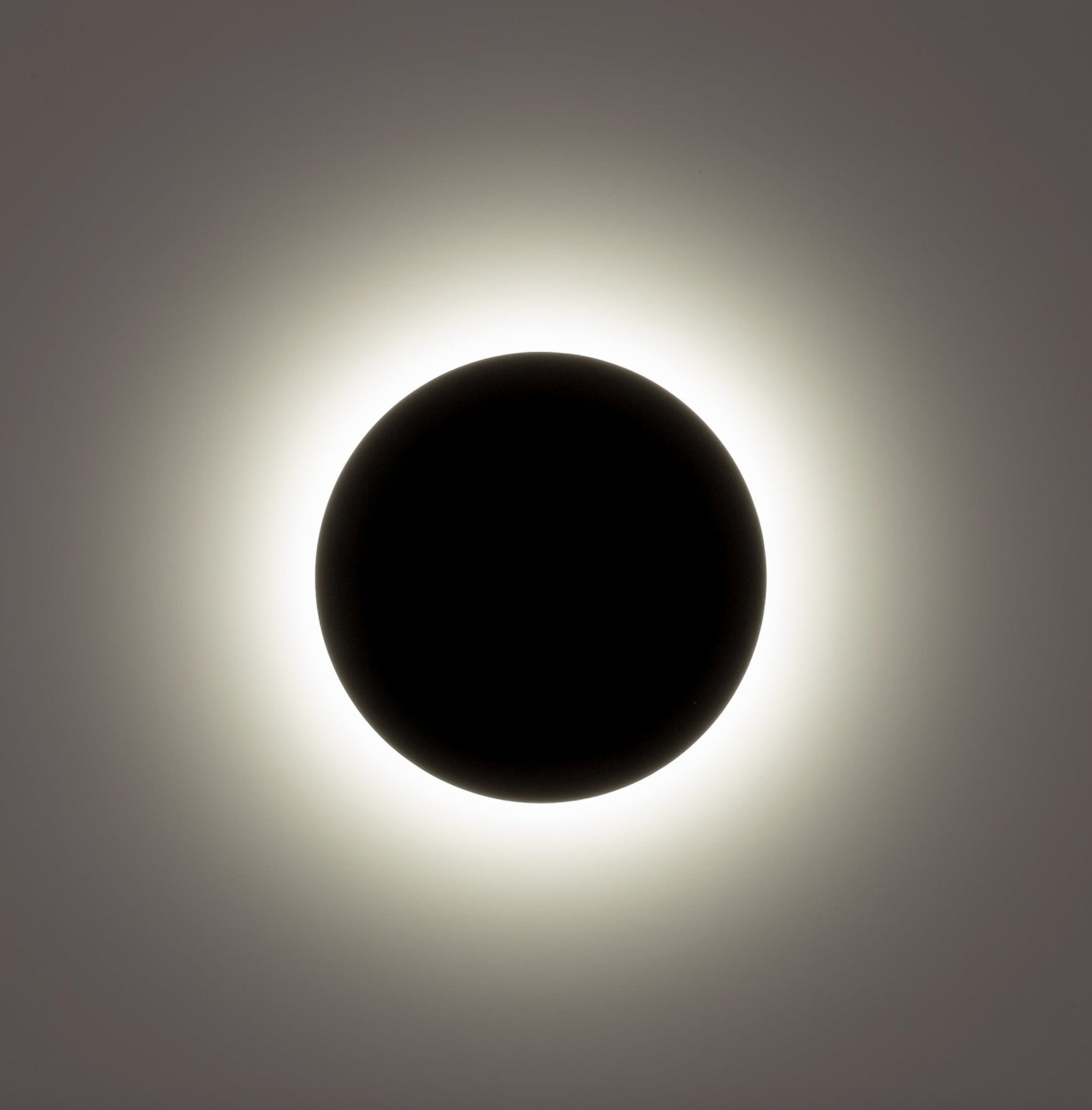 Black wall light with a dark circle in the center on a grey background