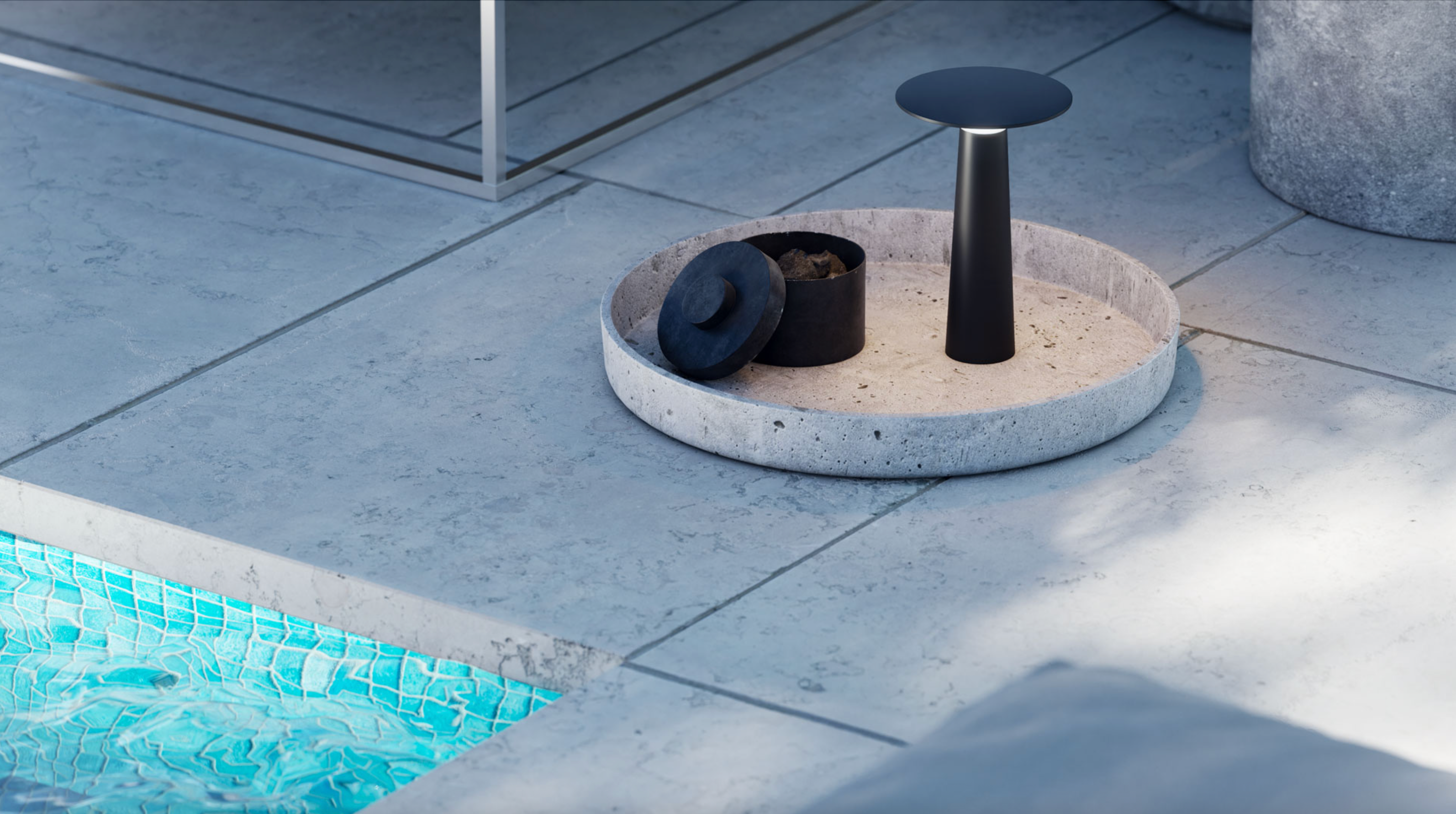 Modern outdoor chair with concrete base and black seat on a patio near a pool.