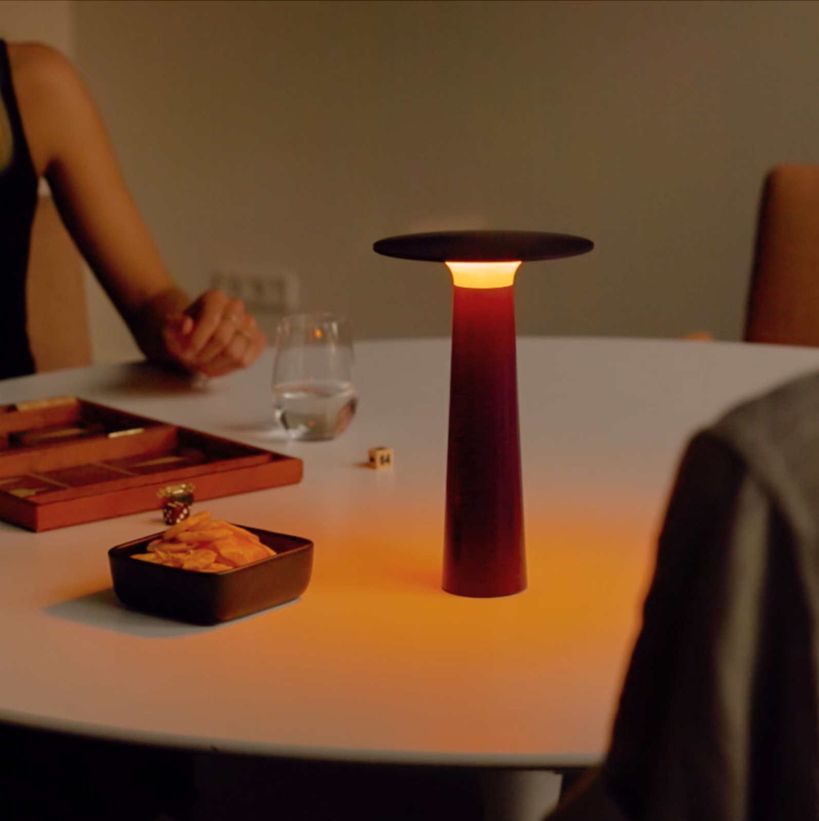 Red table lamp on a dining table with snacks and drinks