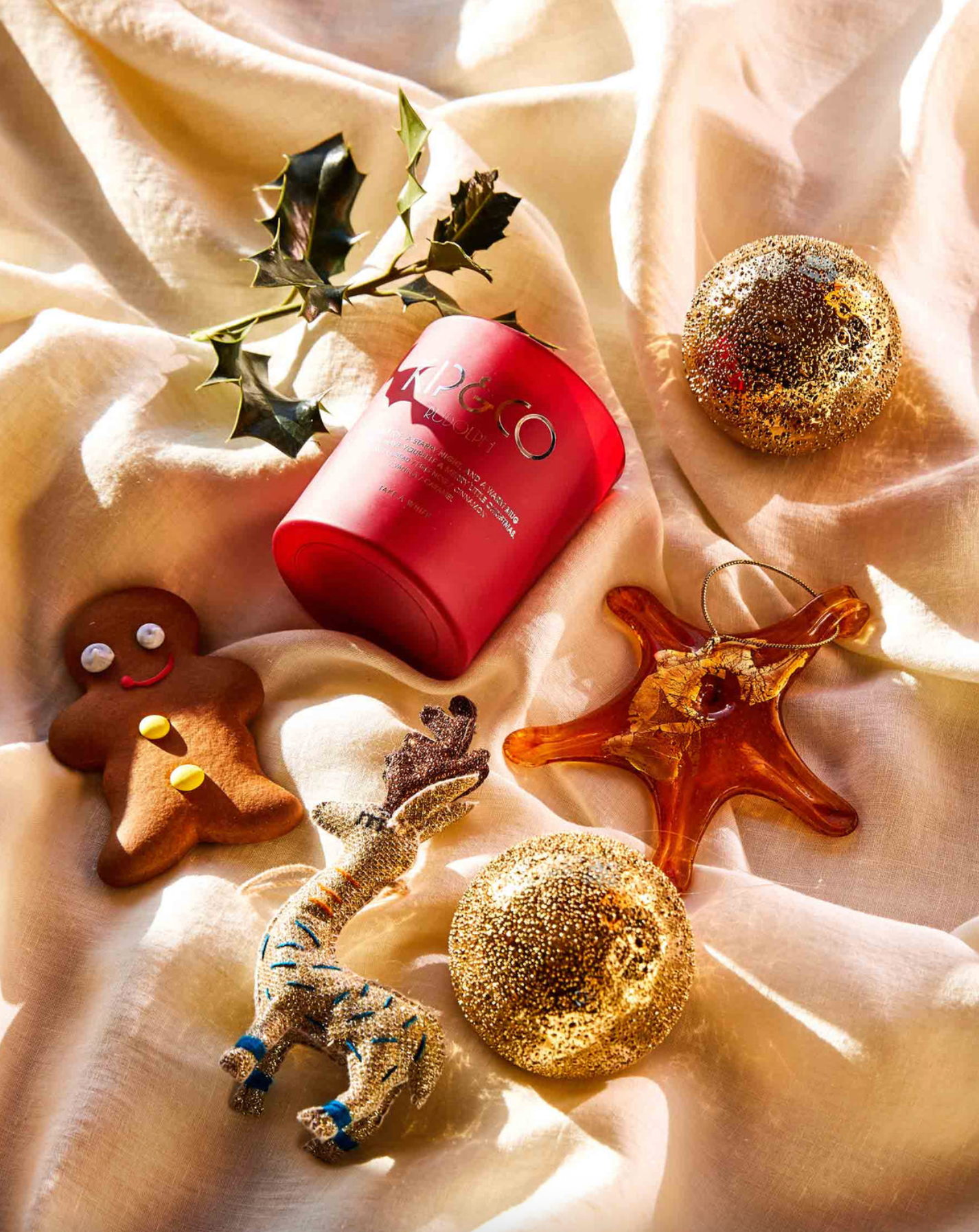 Red cylindrical container with decorative items on a beige fabric background