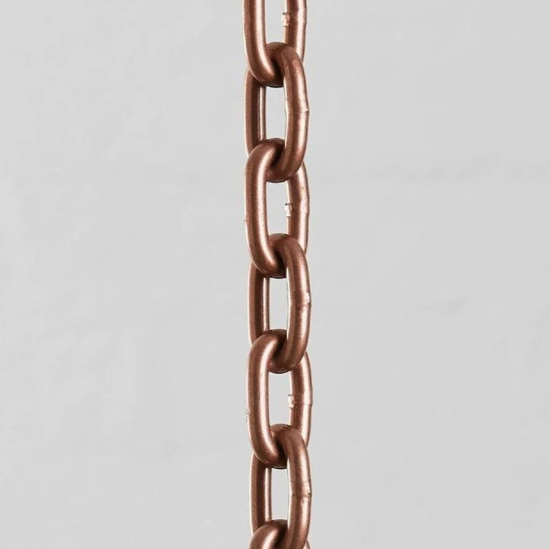 Close-up of a copper chain on a light gray background